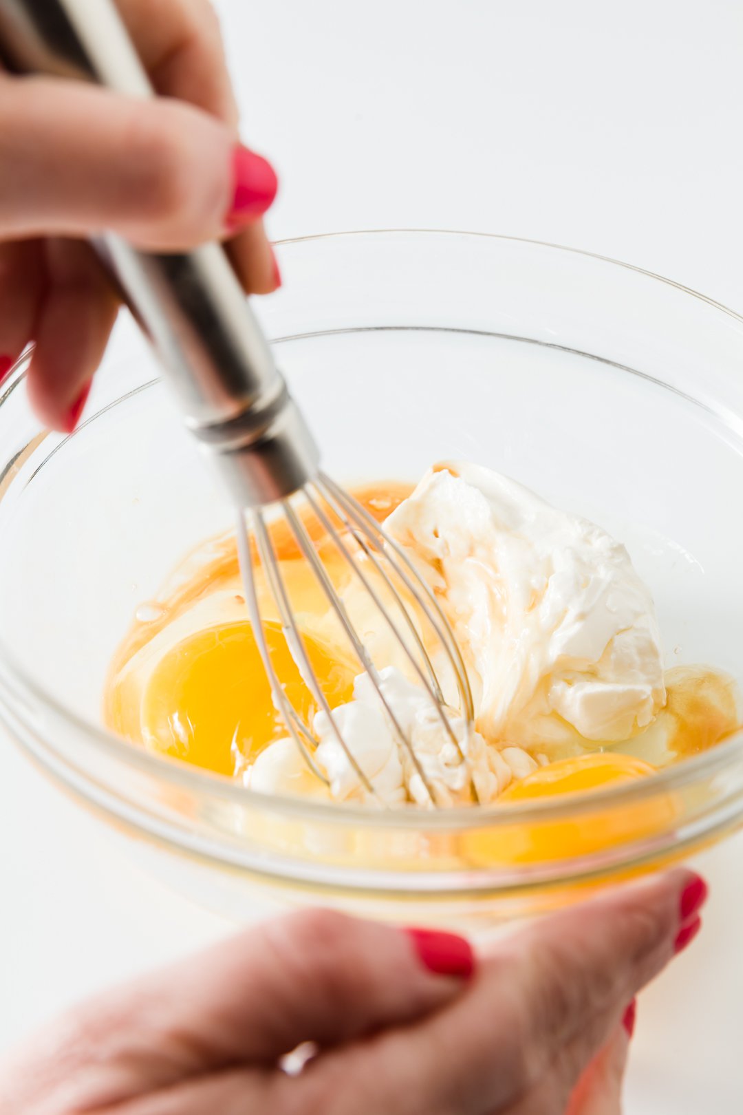 Whisking eggs, sour cream, and vanilla 