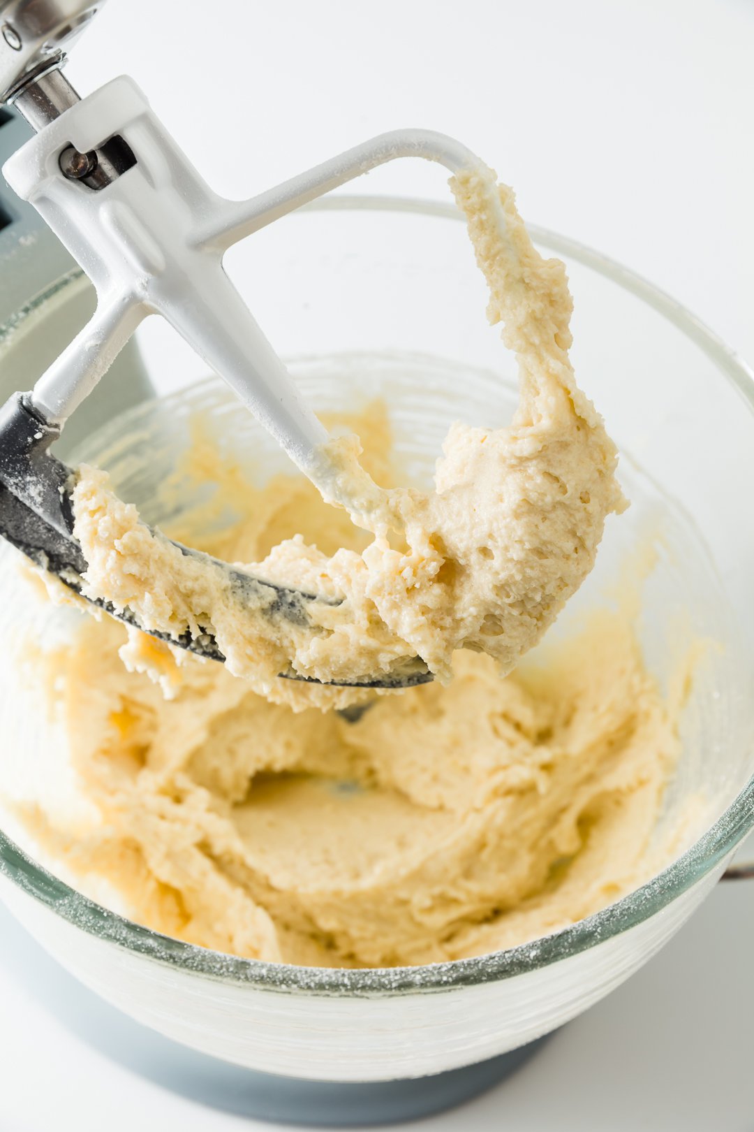 Cupcake batter in the bowl of a stand mixer with the blade lifted