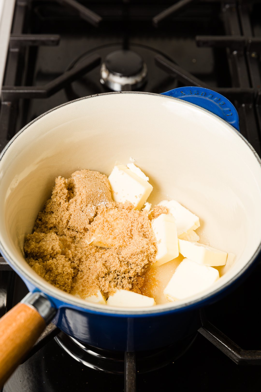 Caramel ingredients in a small blue pot on a stove