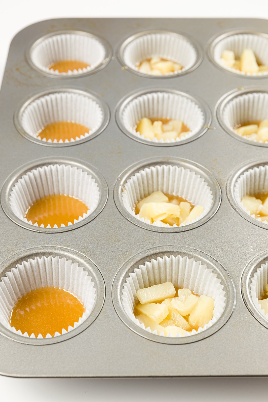 Adding pineapple to cupcake liners