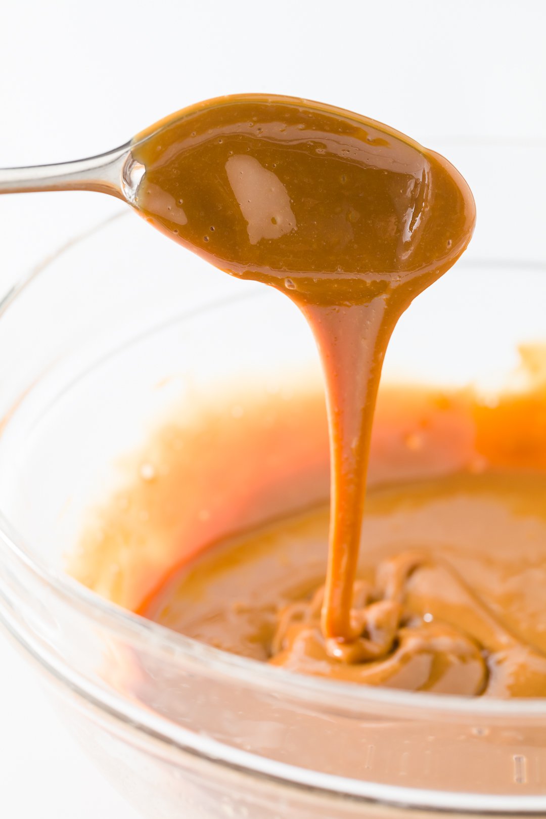 Dulce de leche dripping off of a spoon