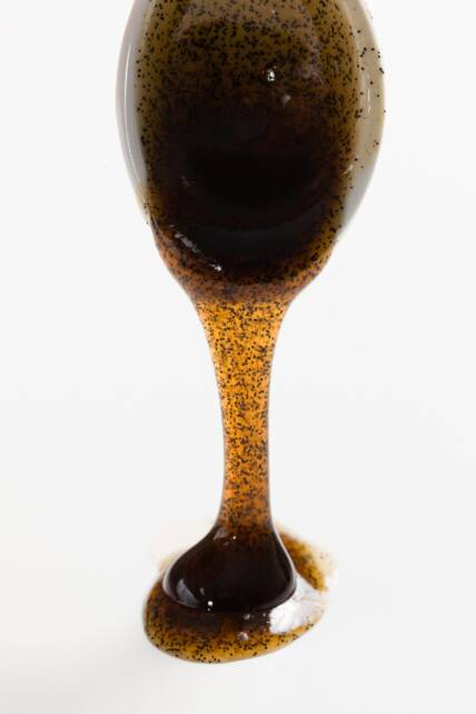 espesa pasta de vainilla que gotea de una cuchara sobre una mesa