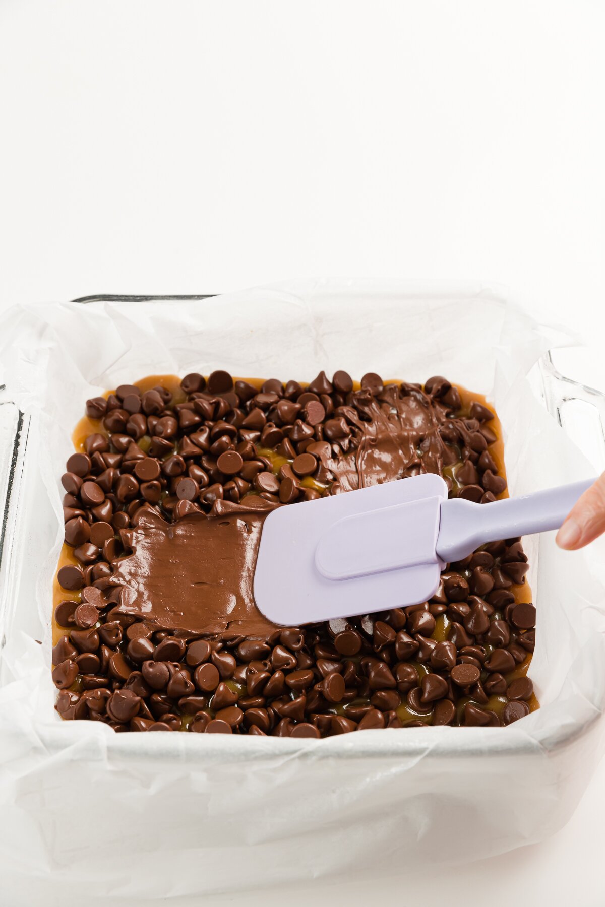 Spreading melted chocolate chips with a purple spatula
