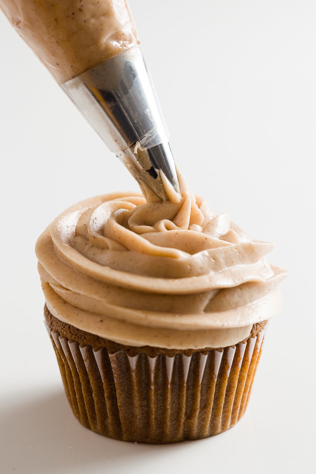 Piping cinnamon cream cheese frosting