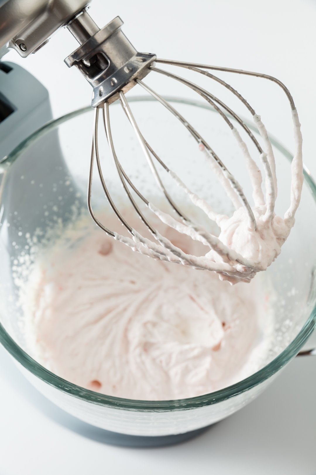 Strawberry Whipped Cream in the bowl of a stand mixer with the whisk attachment