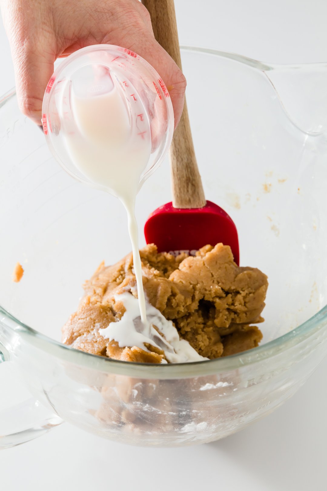 Milk being poured into cookie dough