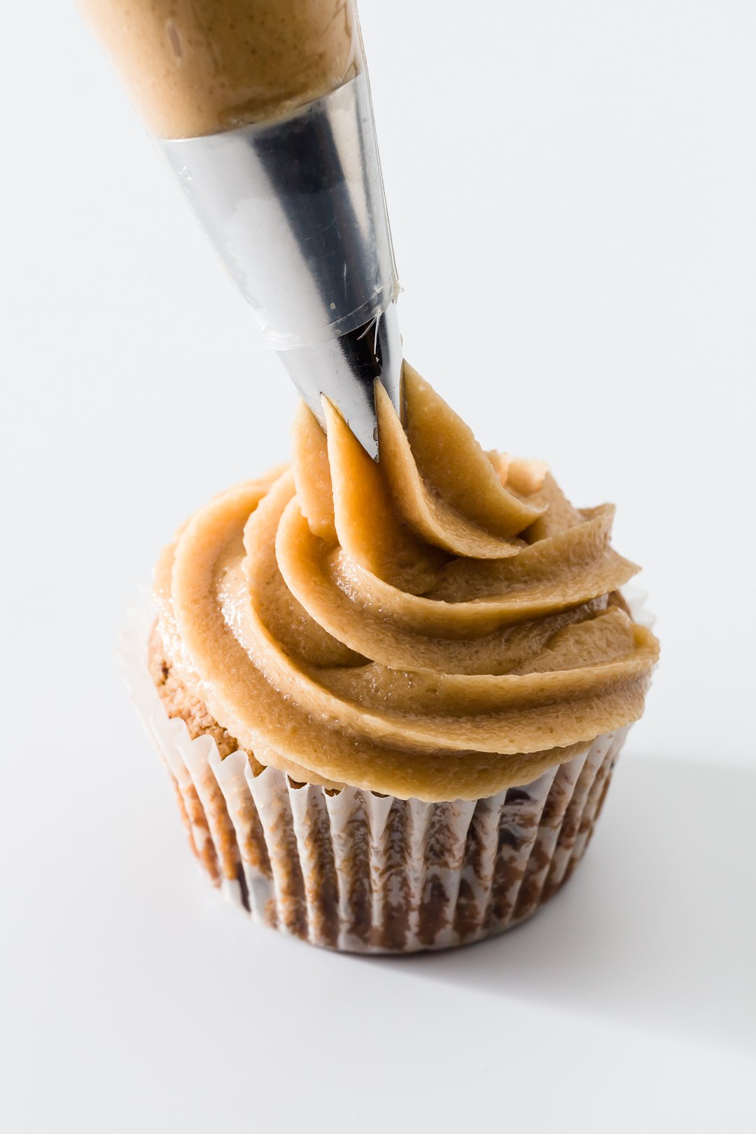 Cookie Dough Frosting being piped onto a cupcake
