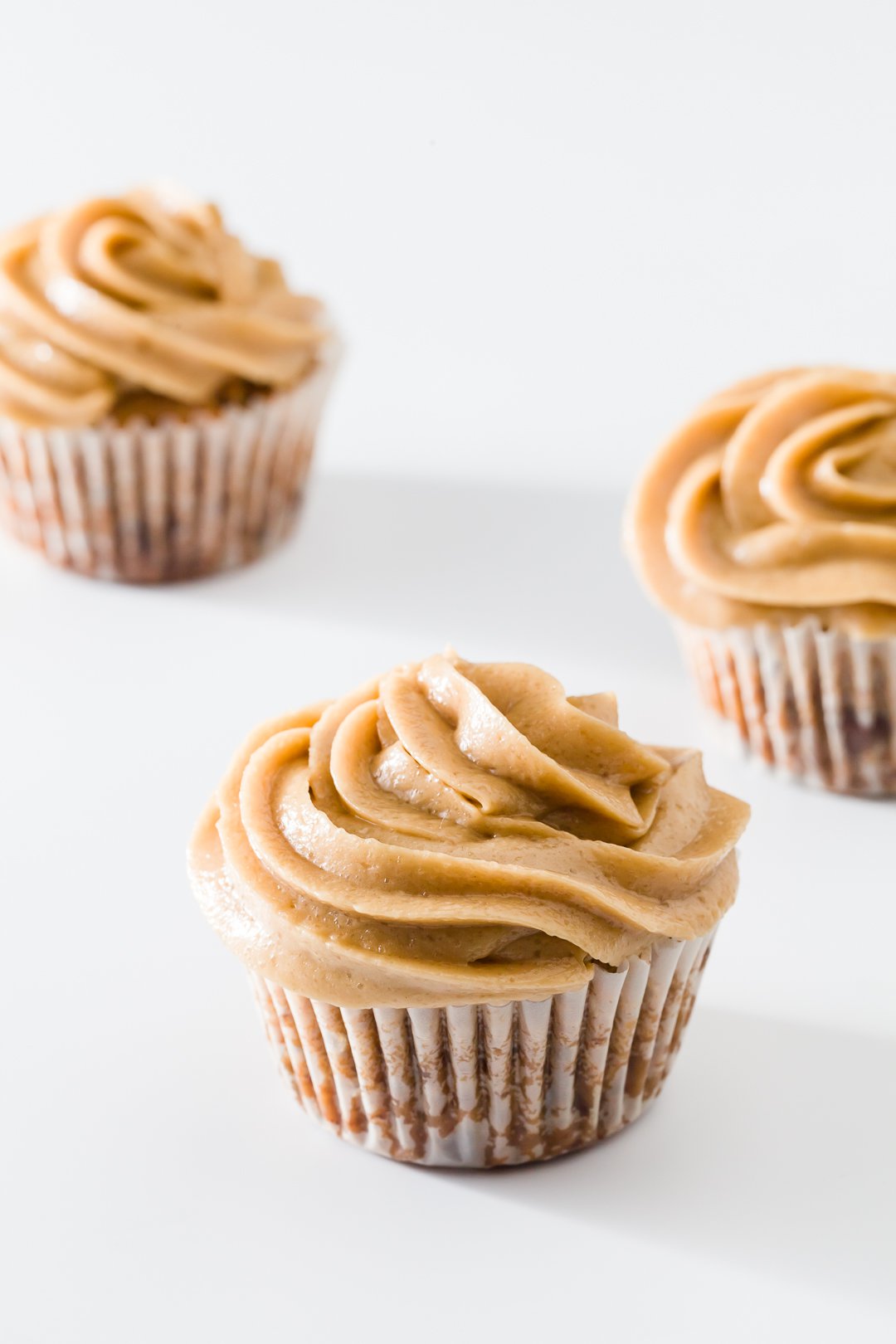 The cupcakes on white background frosted with cookie dough frosting