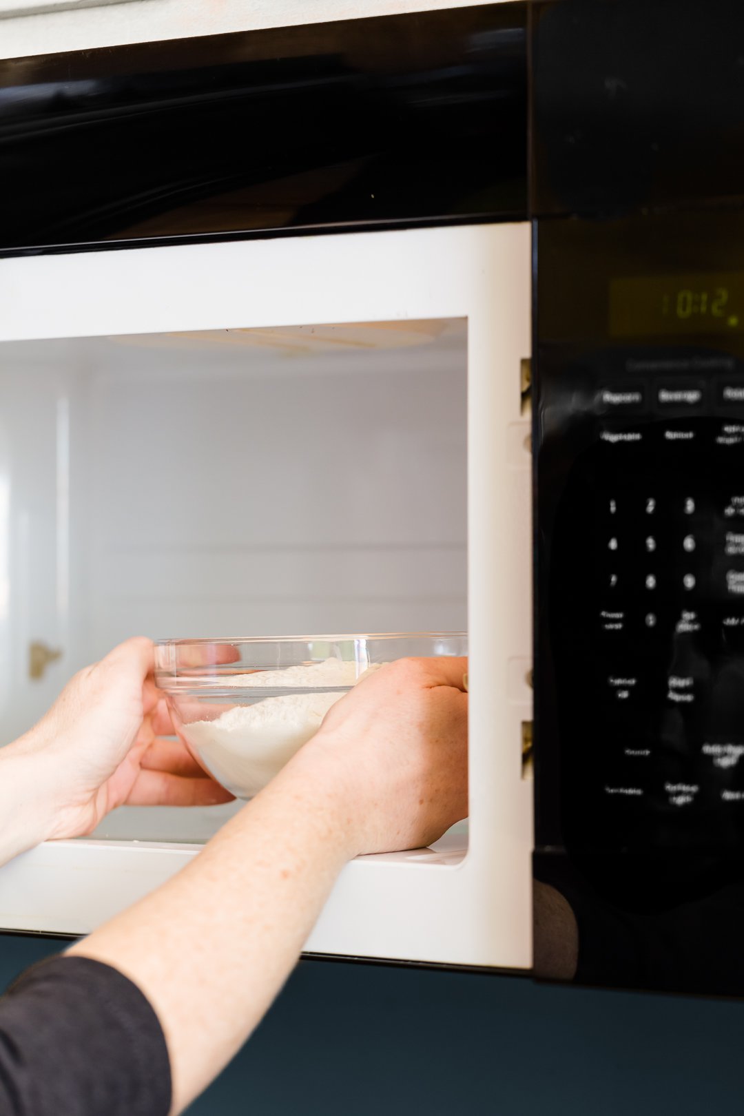 Putting a bowl of flour in the microwave