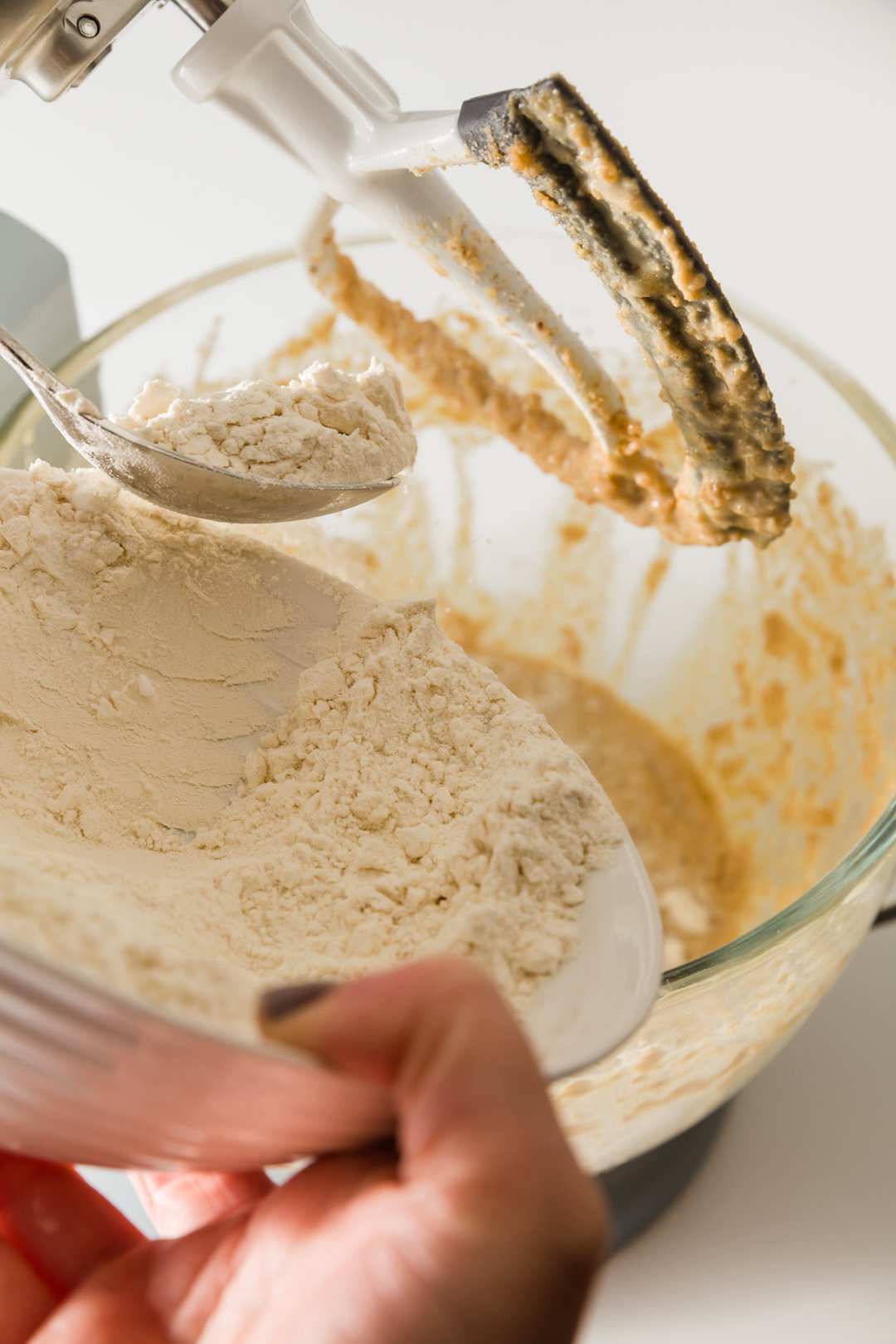 Adding flour to a stand mixer.