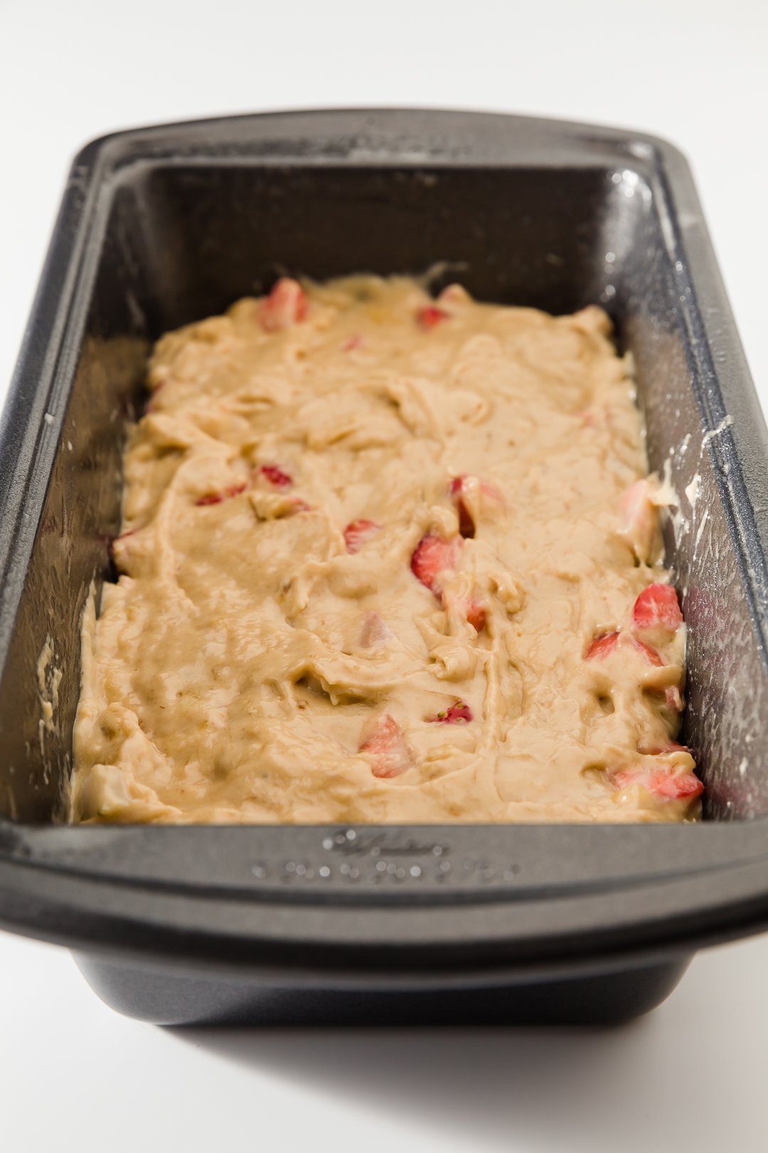 Strawberry banana bread batter in loaf pan
