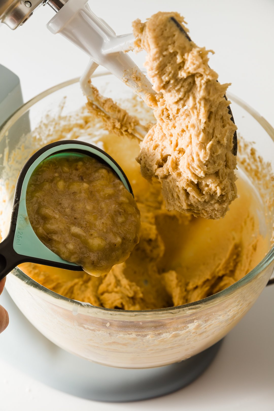 Adding banana to strawberry banana bread batter