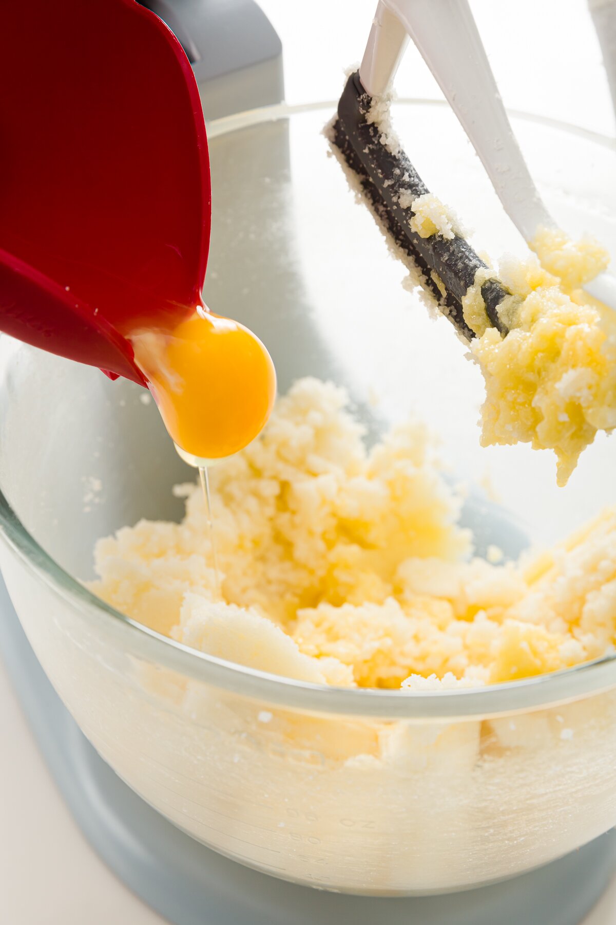 adding an egg to a KitchenAid mixer bowl