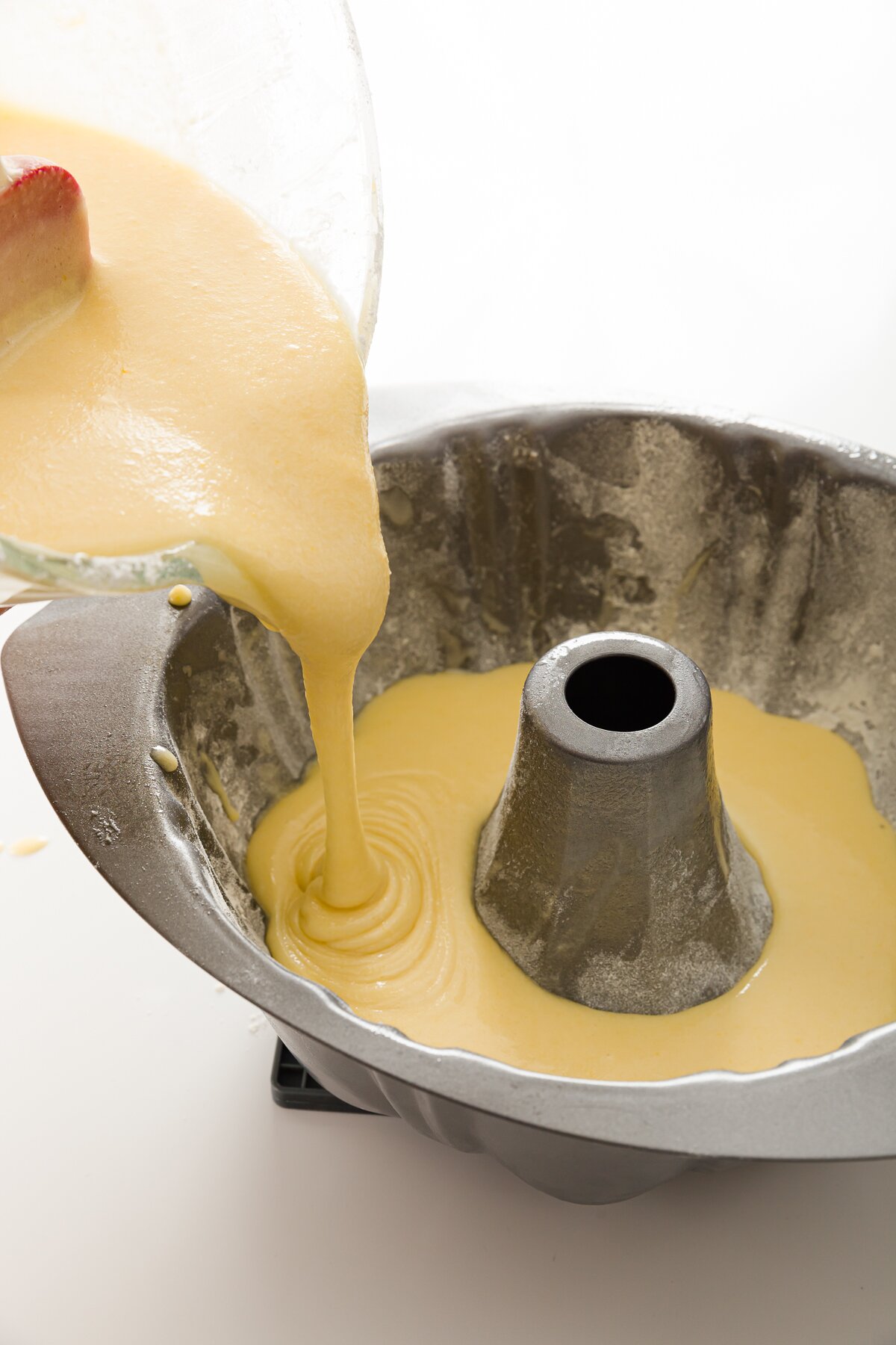 Pouring pound cake batter into a bundt pan