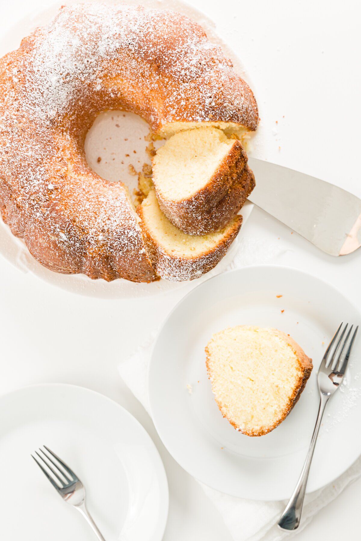 Pound cake with a slice removed and placed on a separate plate with a fork