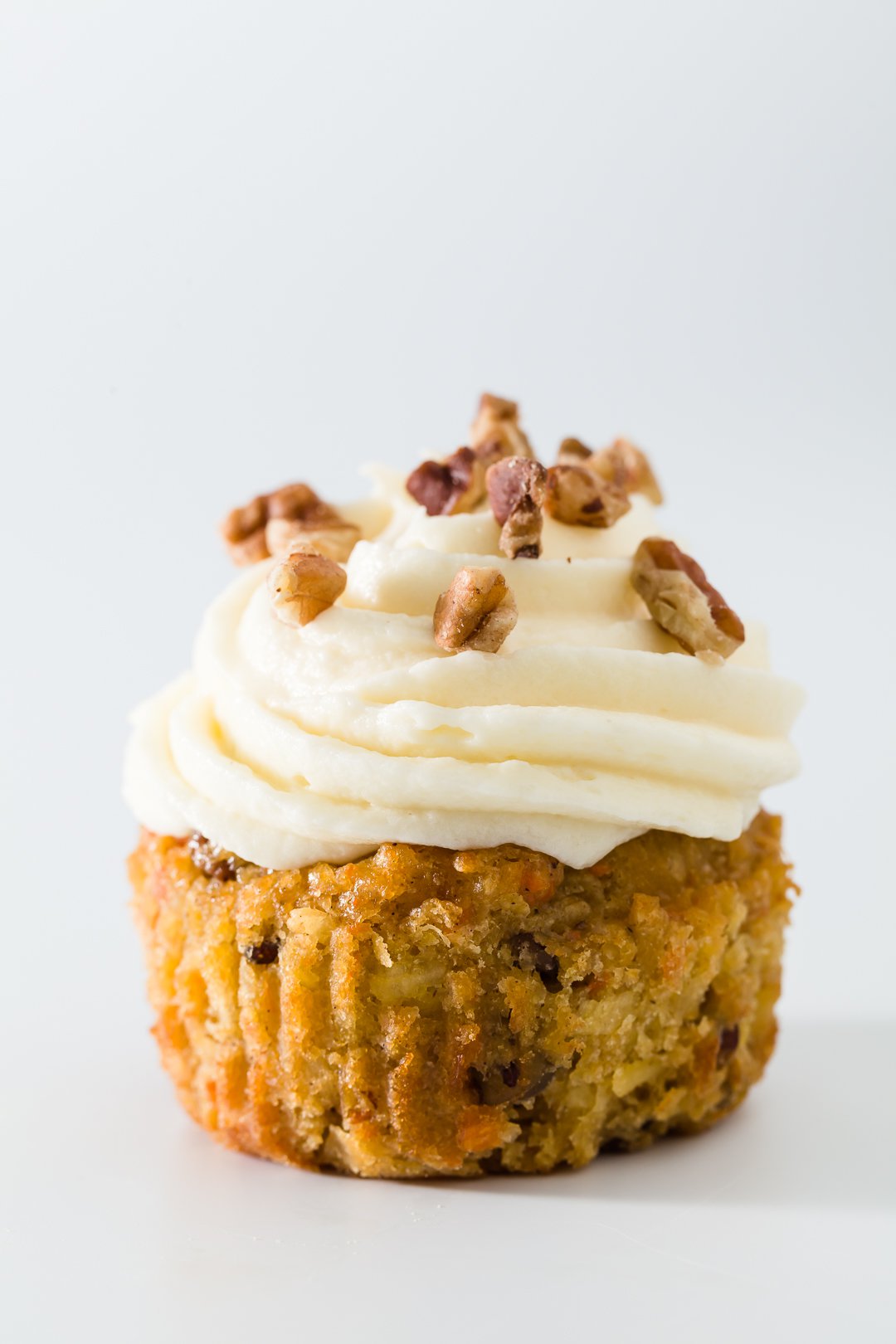 Carrot Cake Cupcakes topped with chopped pecans