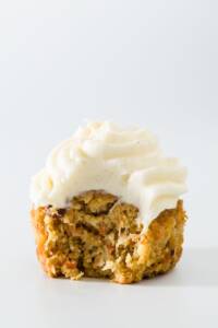 One carrot cake cupcake with a bite taken out of it