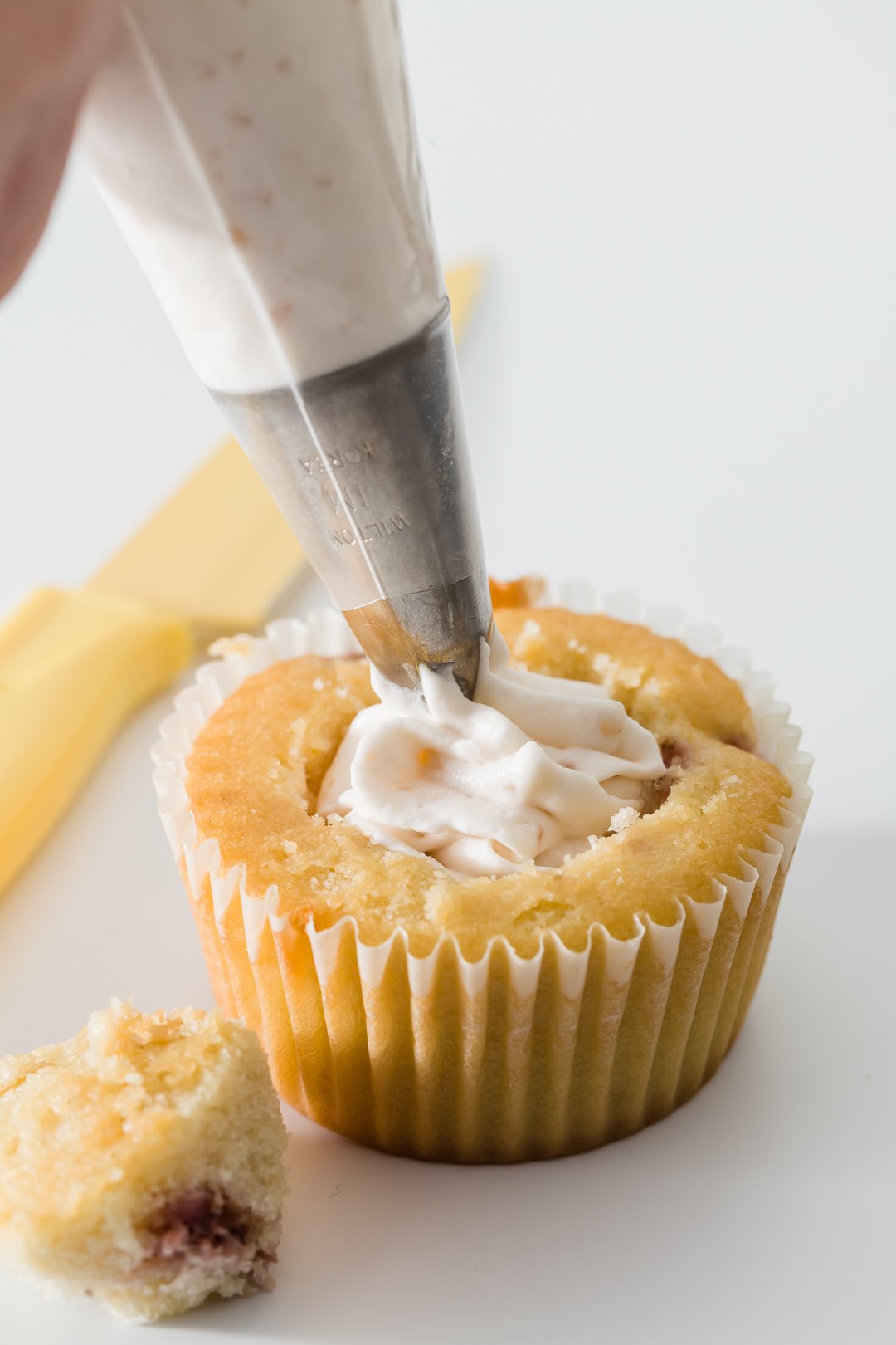 Filling a cupcake with a piping bag