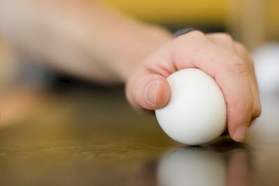 An egg being cracked on flat surface