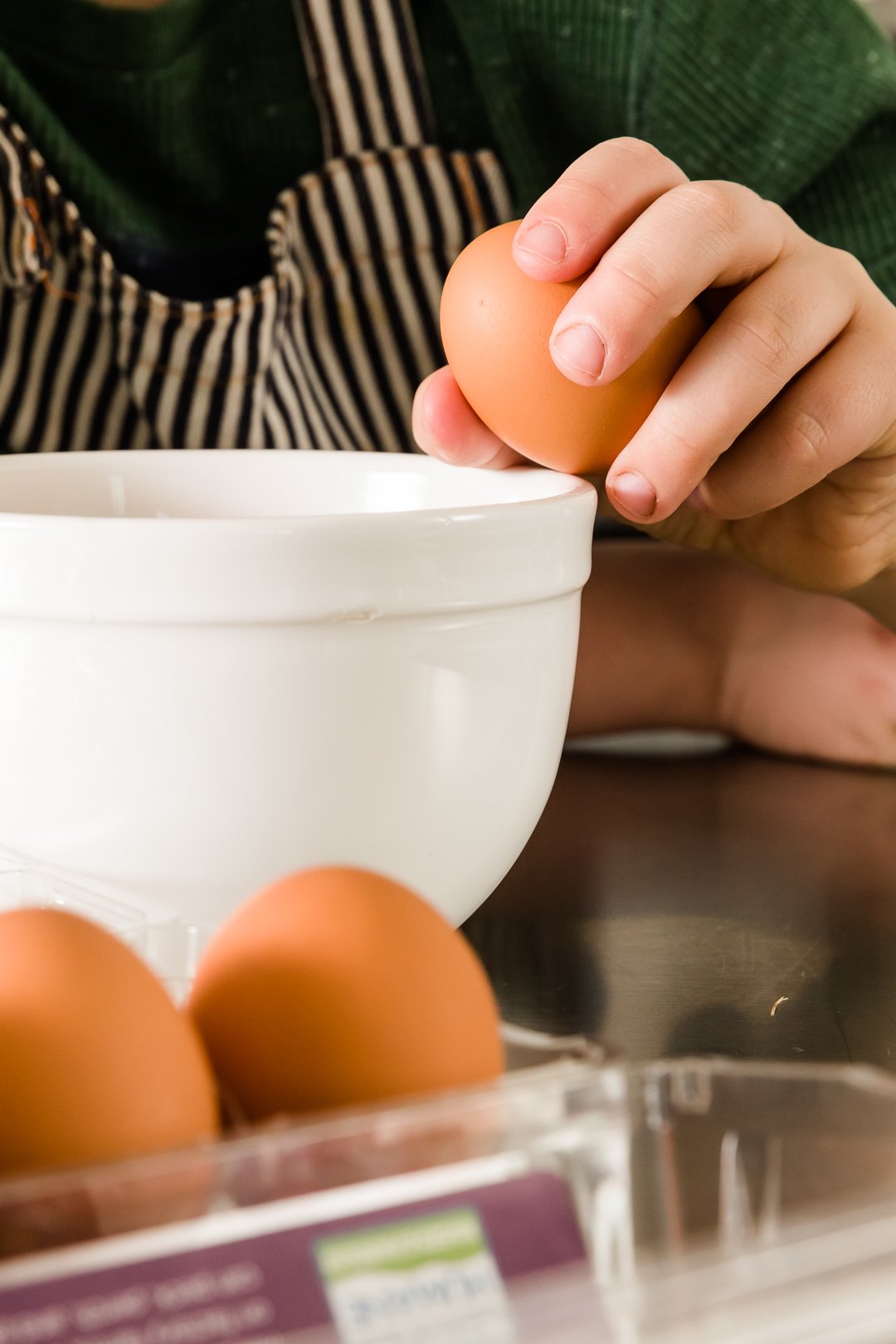 Myles cracking an egg on the edge of a bowl