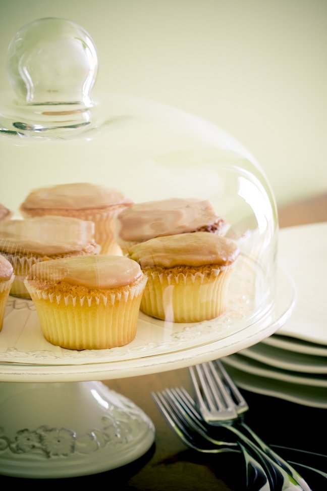 homemade caramel icing on top of caramel cupcakes on a cake stand