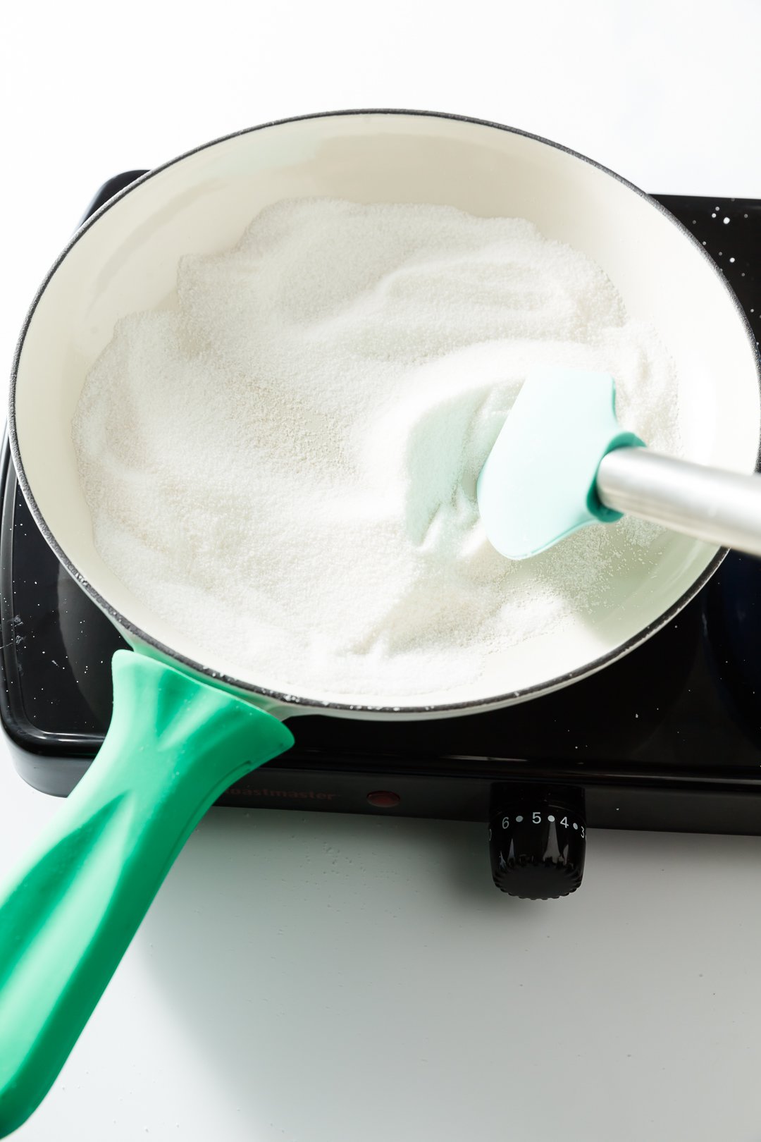 Sugar pushed with a spatula in a skillet