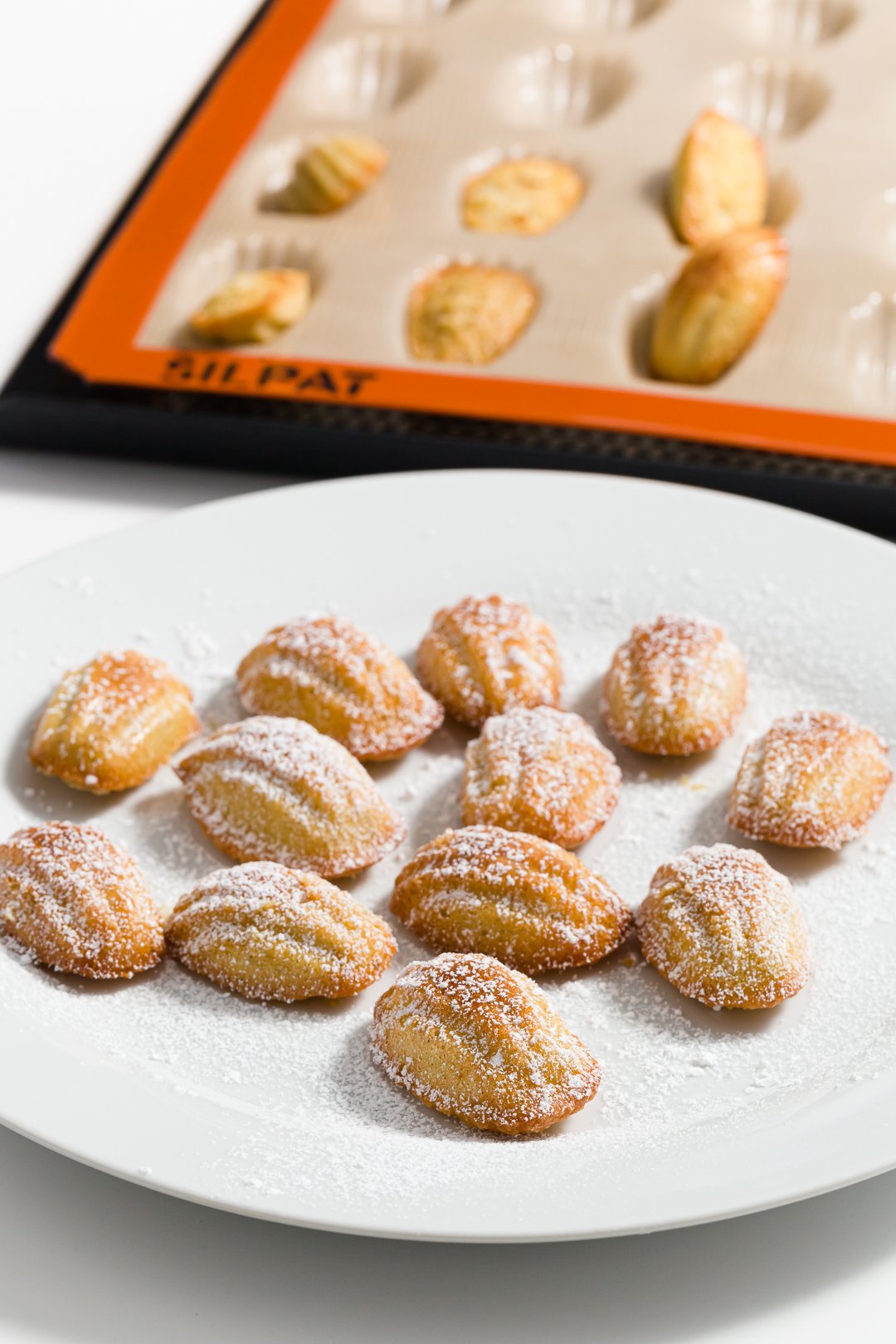 Mini Madeleines on a plate in front of a Silpat