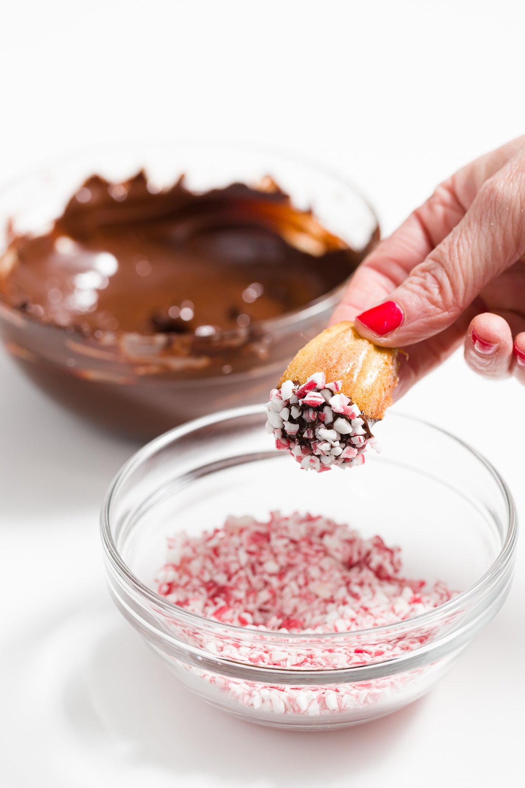 Chocolate dipped madeleines rolled in candy canes