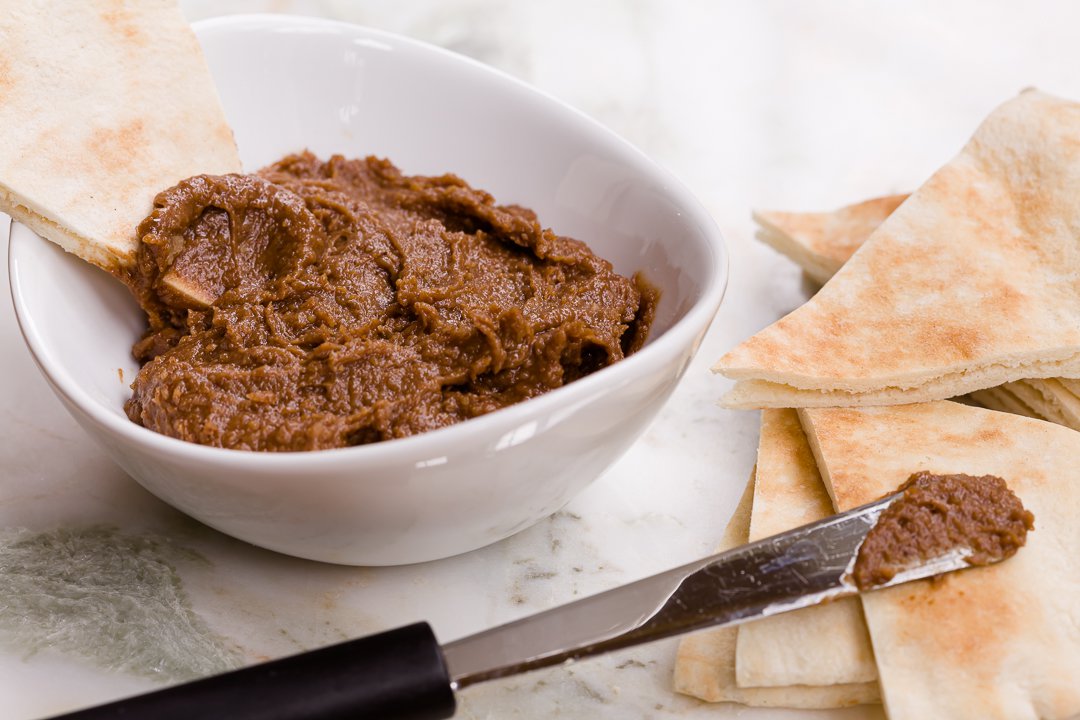 Chocolate hummus in a bowl with fresh pita bread nearby