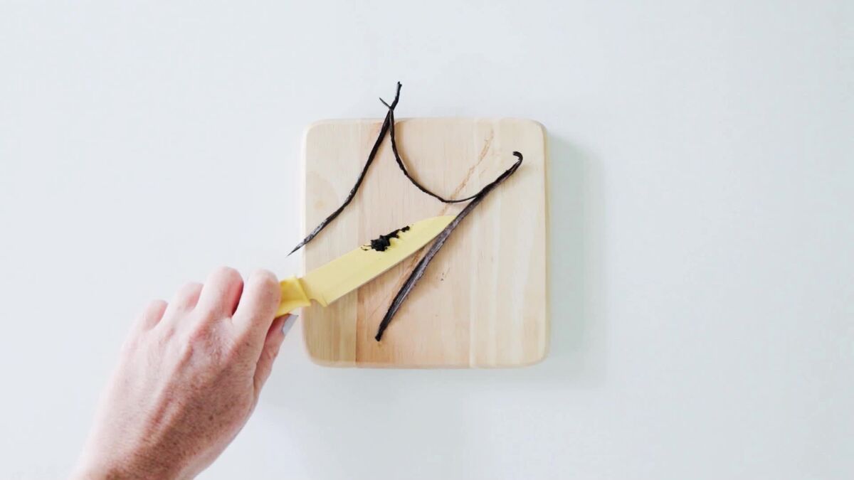 Scraping a vanilla bean on a cutting board to make vanilla sugar