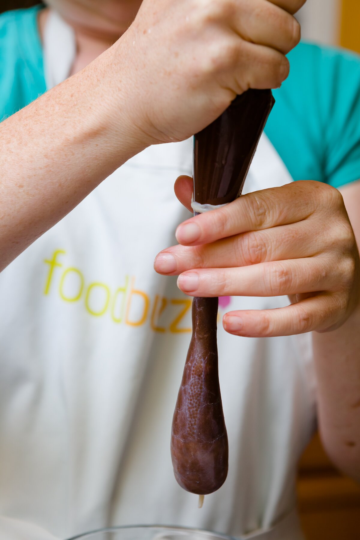 Stef filling a sausage casing with cupcake batter