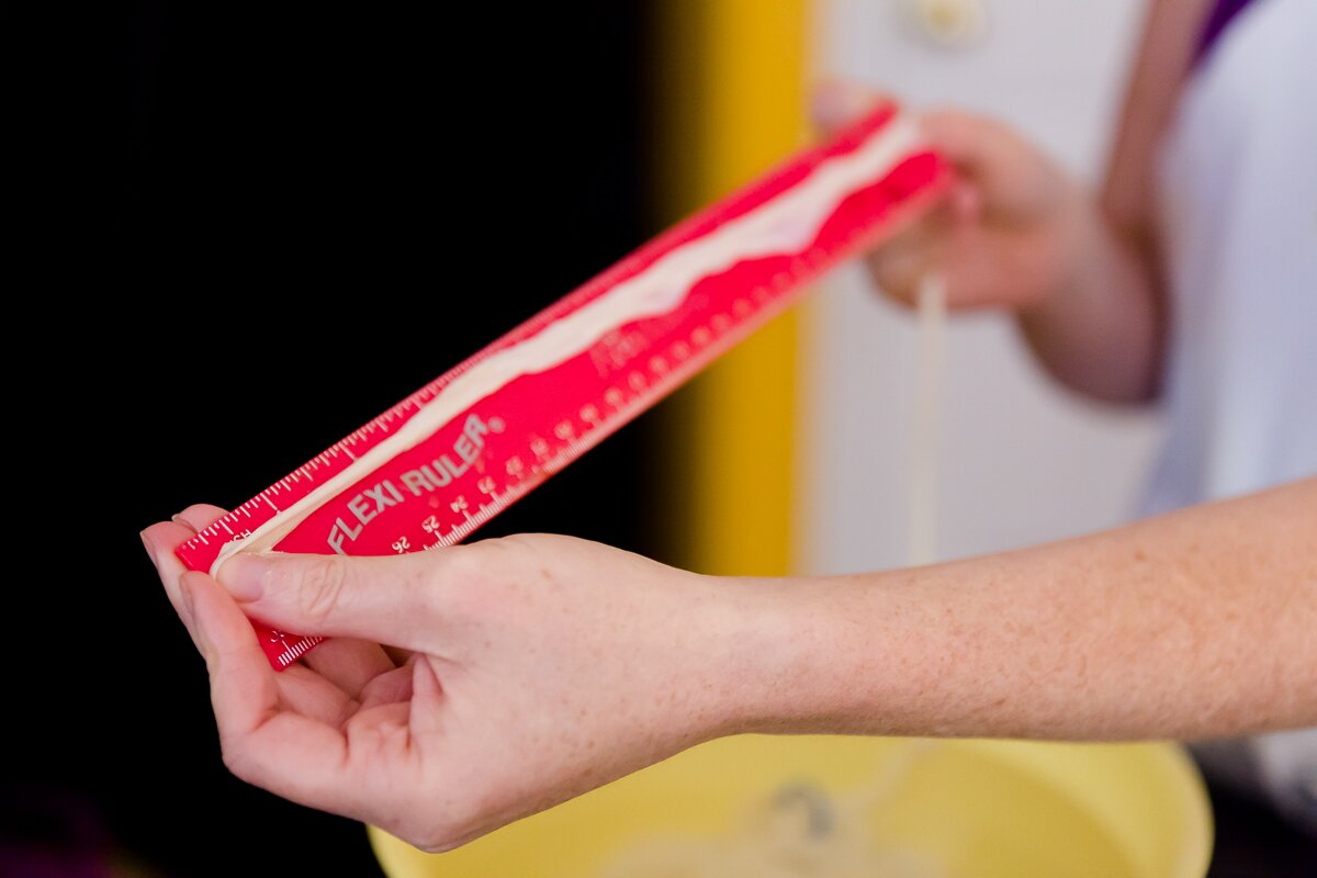 Stef holding up sausage casing to a ruler to measure out 12 inches of length