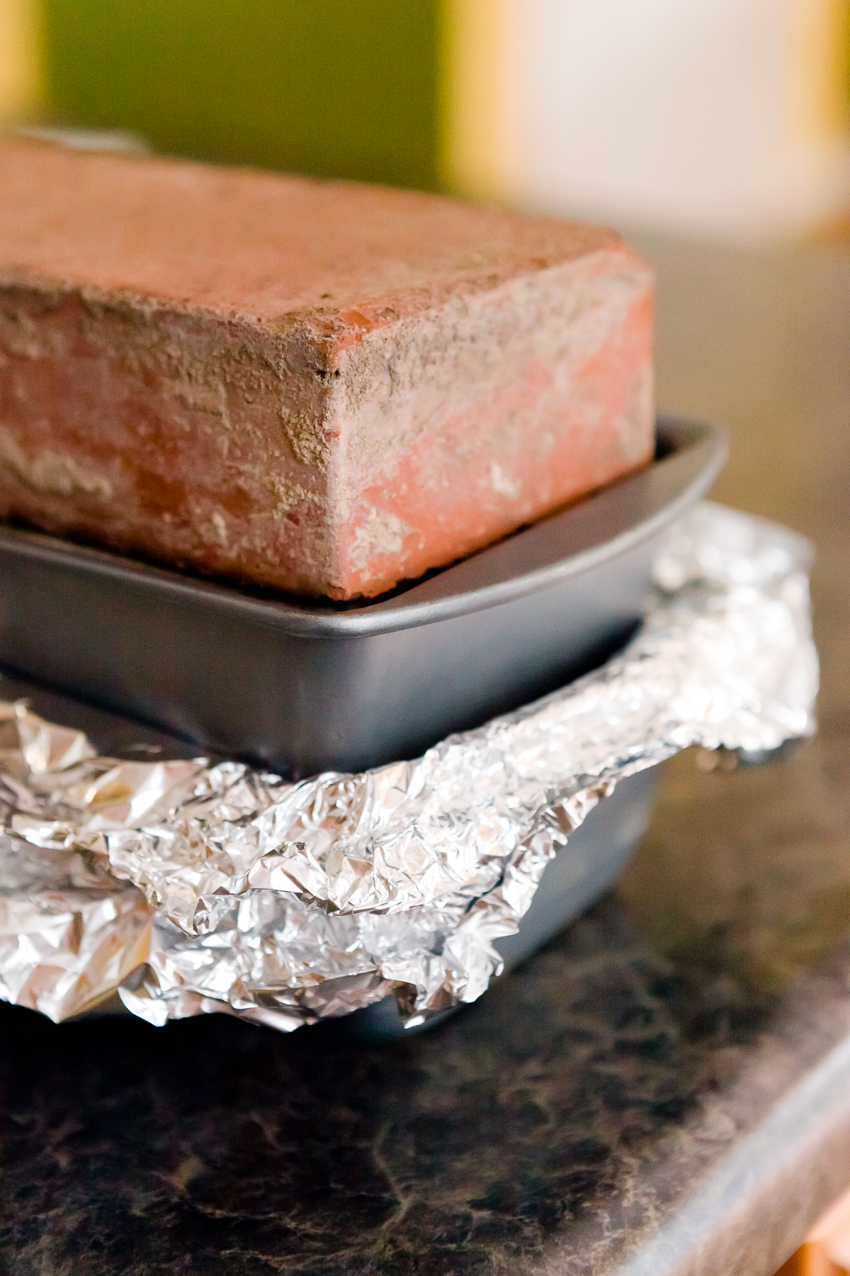 view of bricks in a loaf pan pressing down on covered, drained homemade Spam in another loaf pan