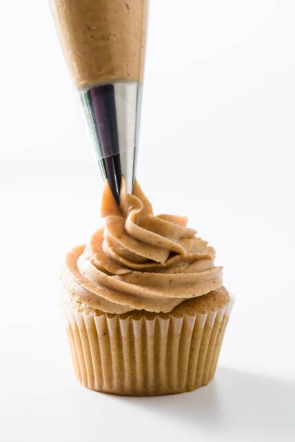 Glaseado de mantequilla de maní que se coloca en los cupcakes