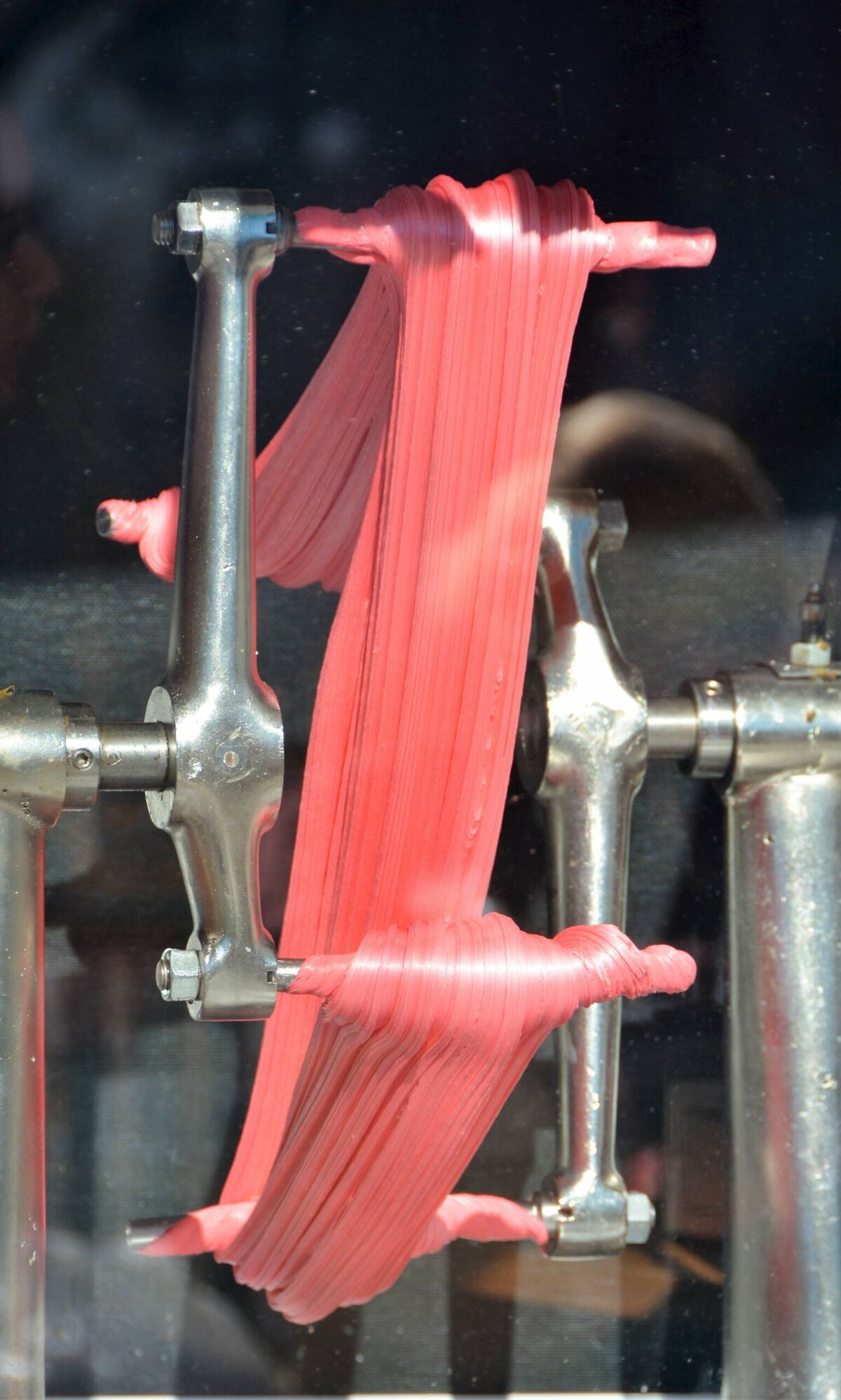 Pink salt water taffy being pulled on a machine