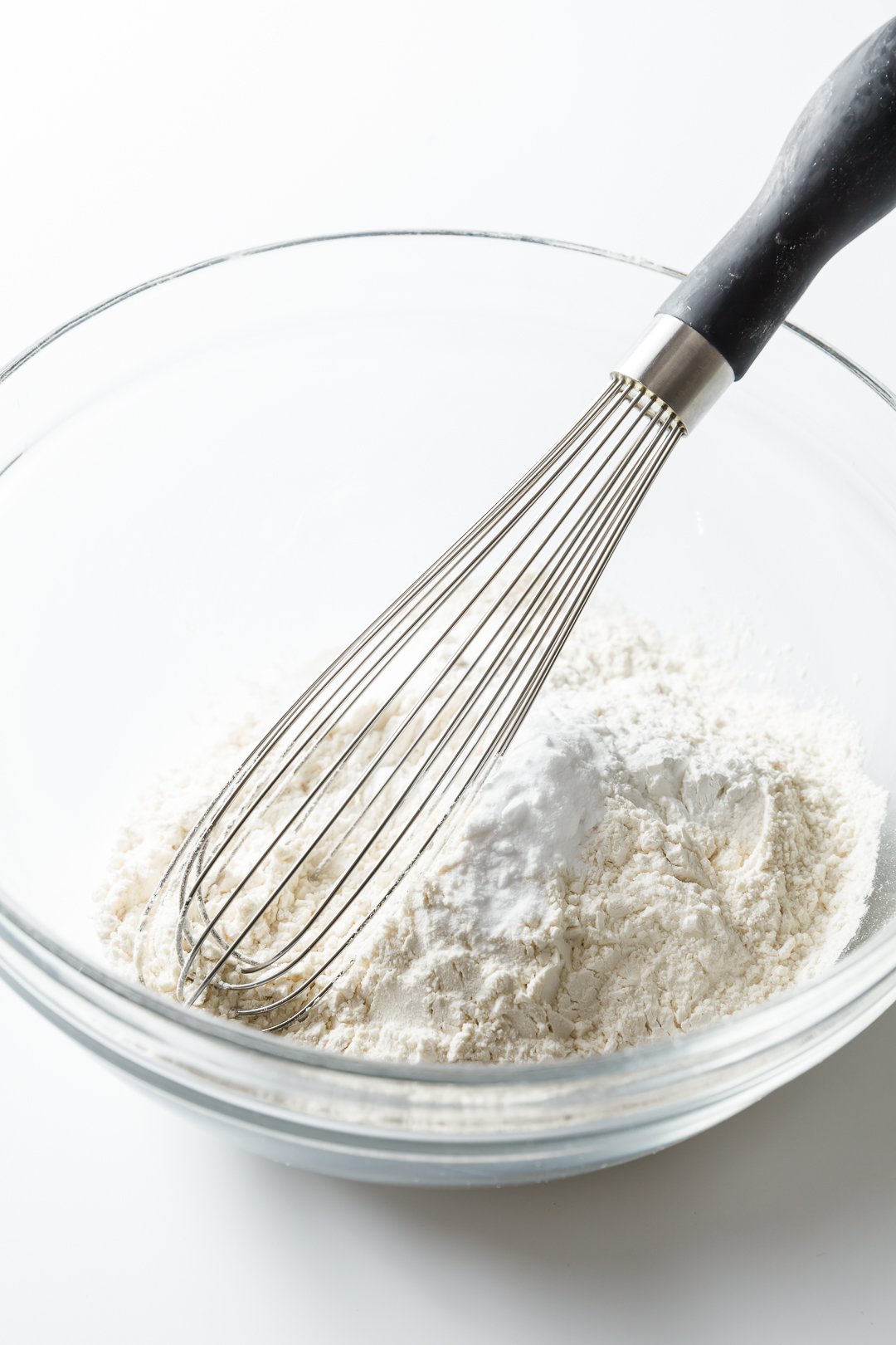 Whisking dry ingredients together in a glass bowl