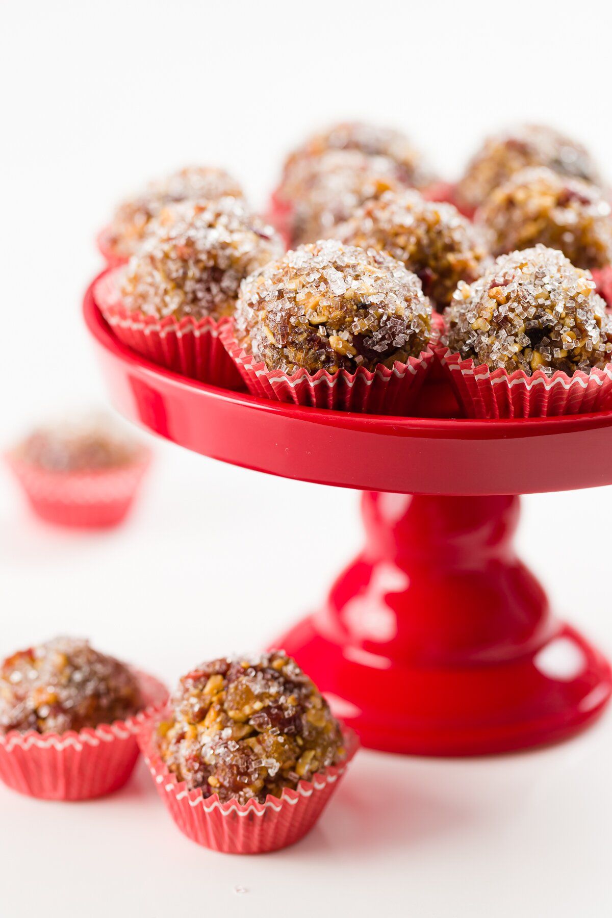 Sugar plums on a red stand with a few in the foreground