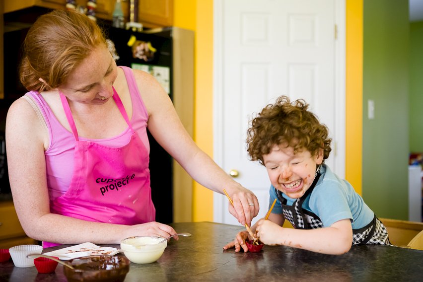 mother and son making chocolate cups together. Toddler laughing.