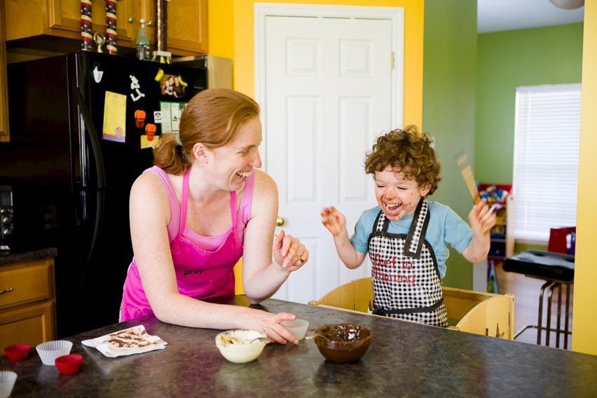 Mother and son having fun making chocolate cups together.