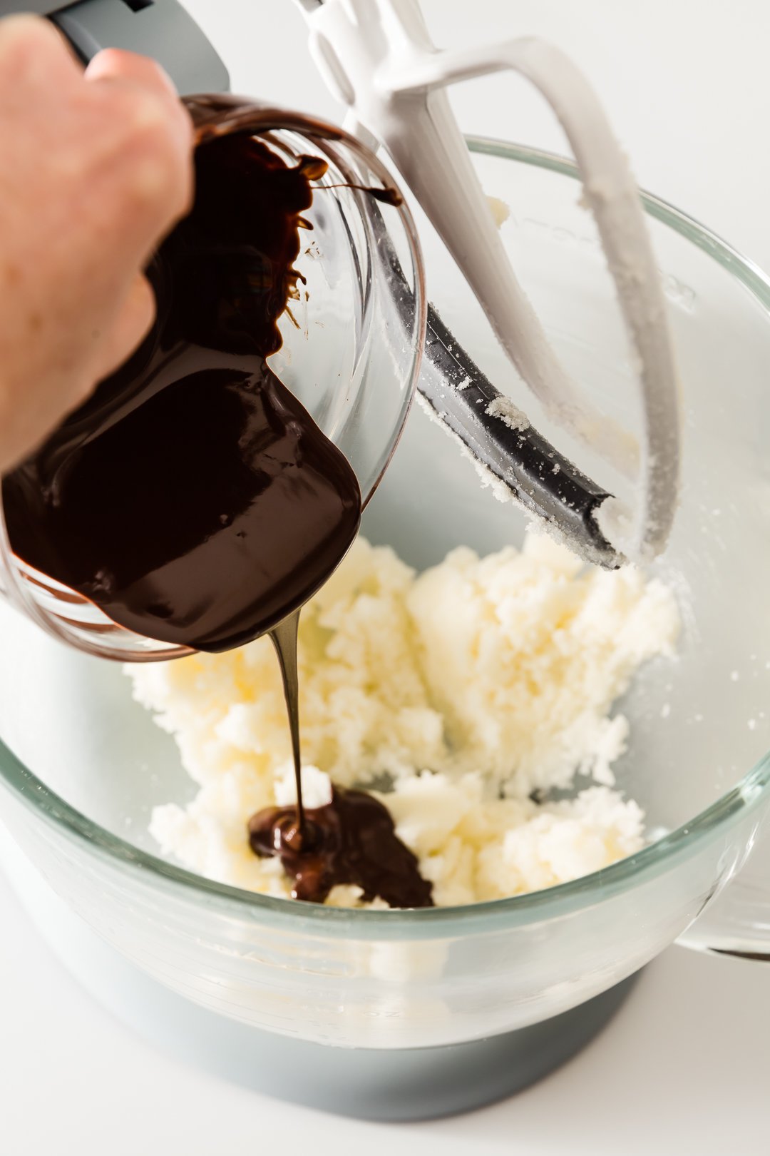 Adding melted chocolate to chocolate cupcake batter