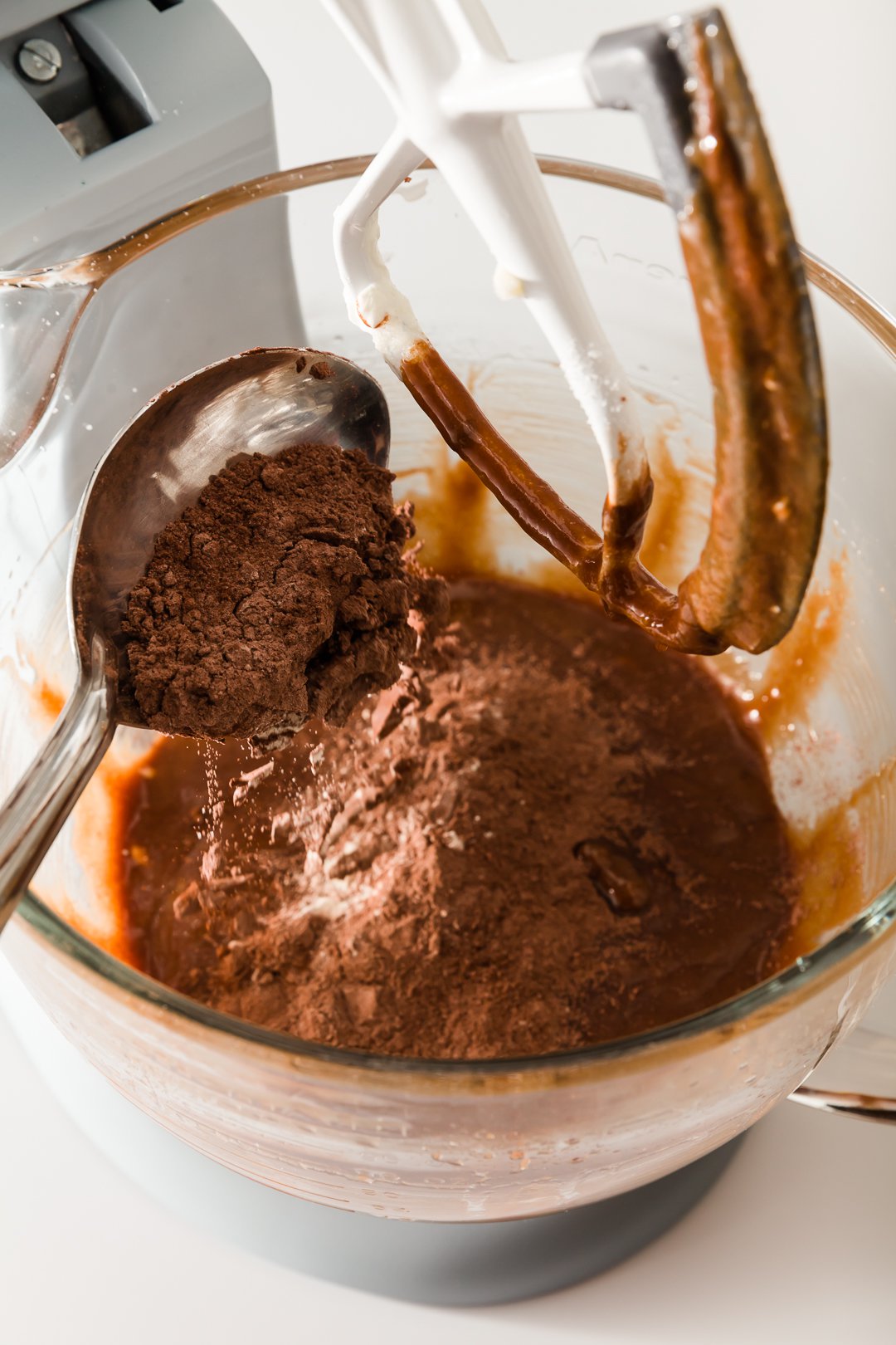 Mixing in dry ingredients to chocolate cupcake batter in a stand mixer