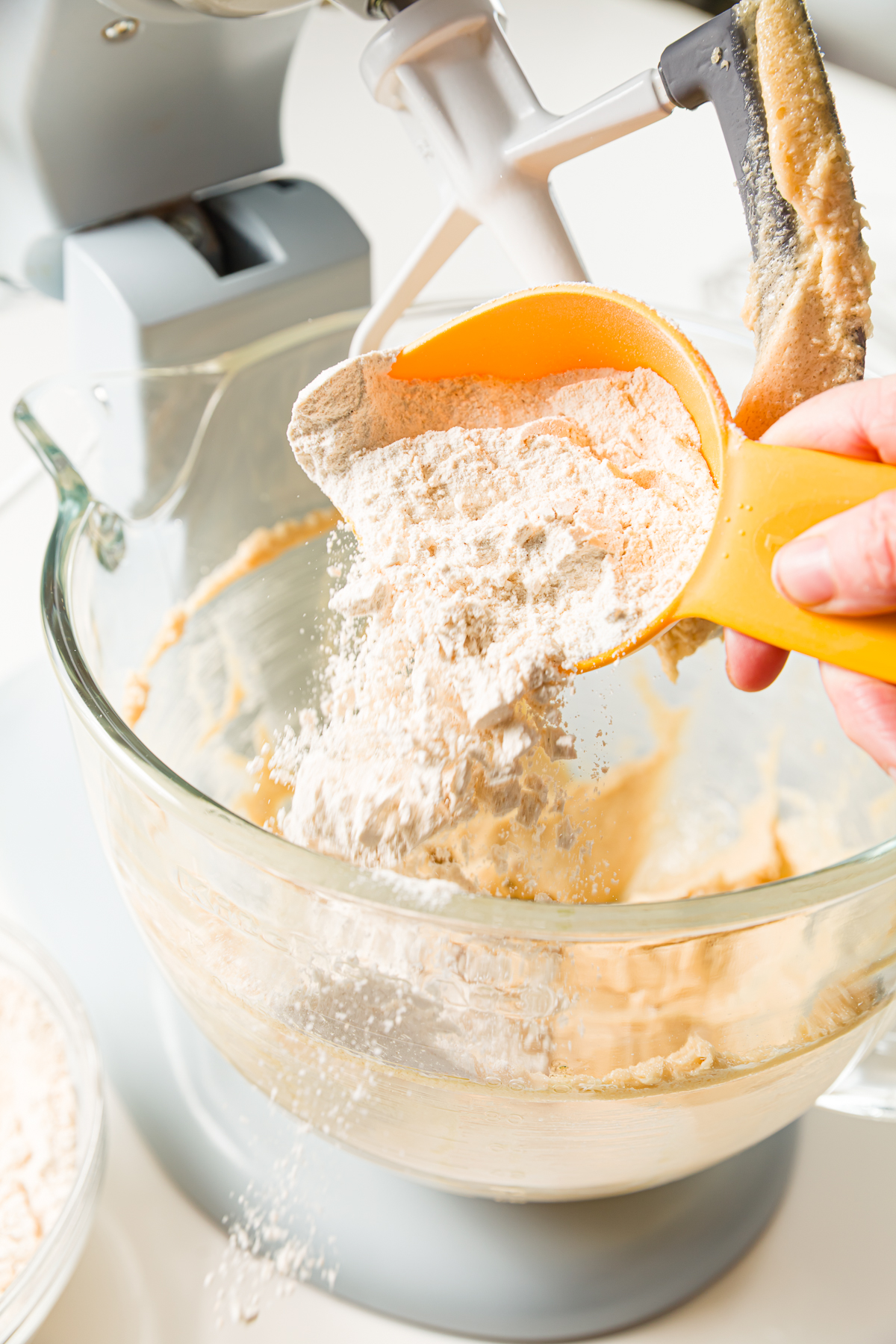 Adding dry ingredients to a mixer bowl