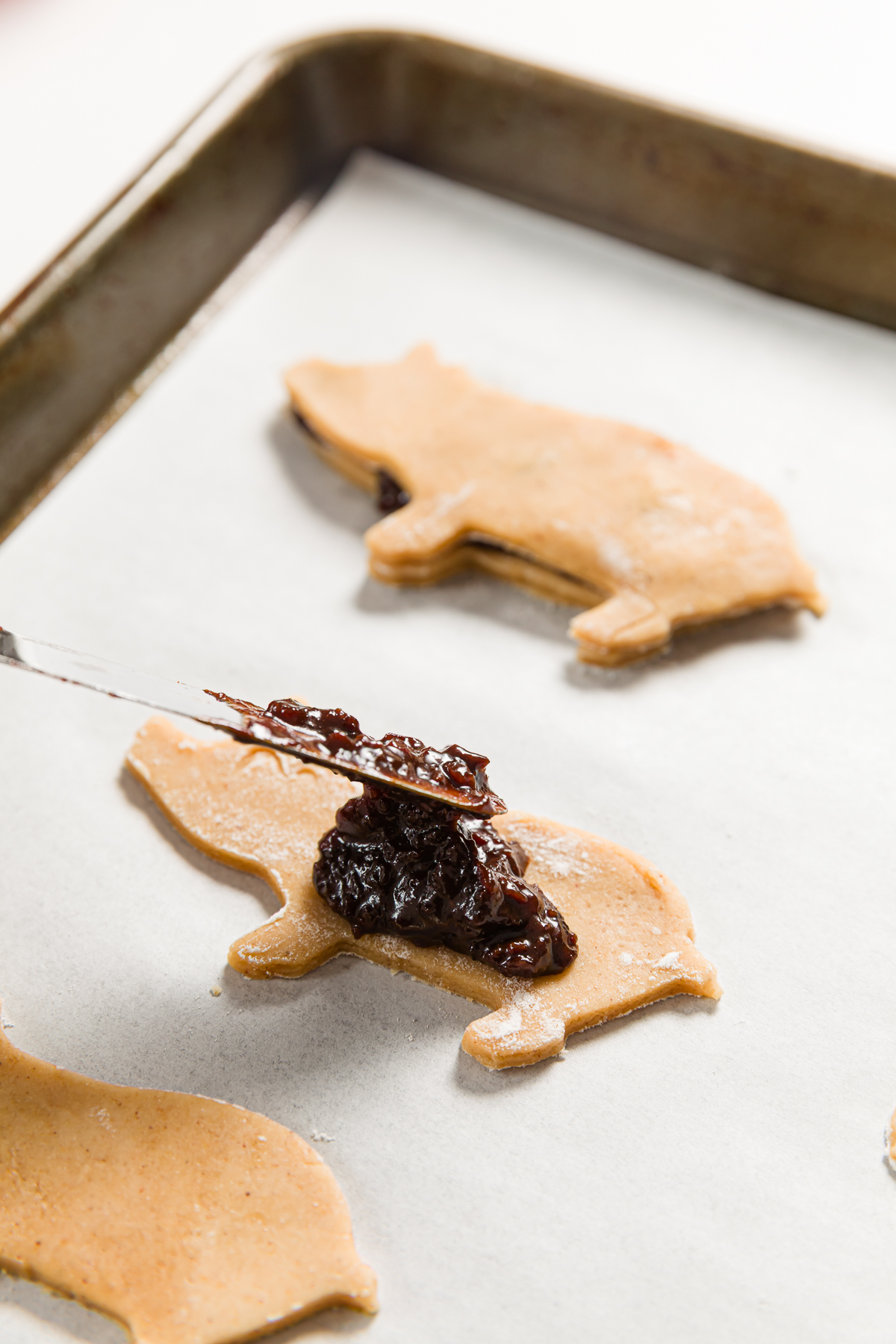 Spreading bacon jam on pig cookie dough.