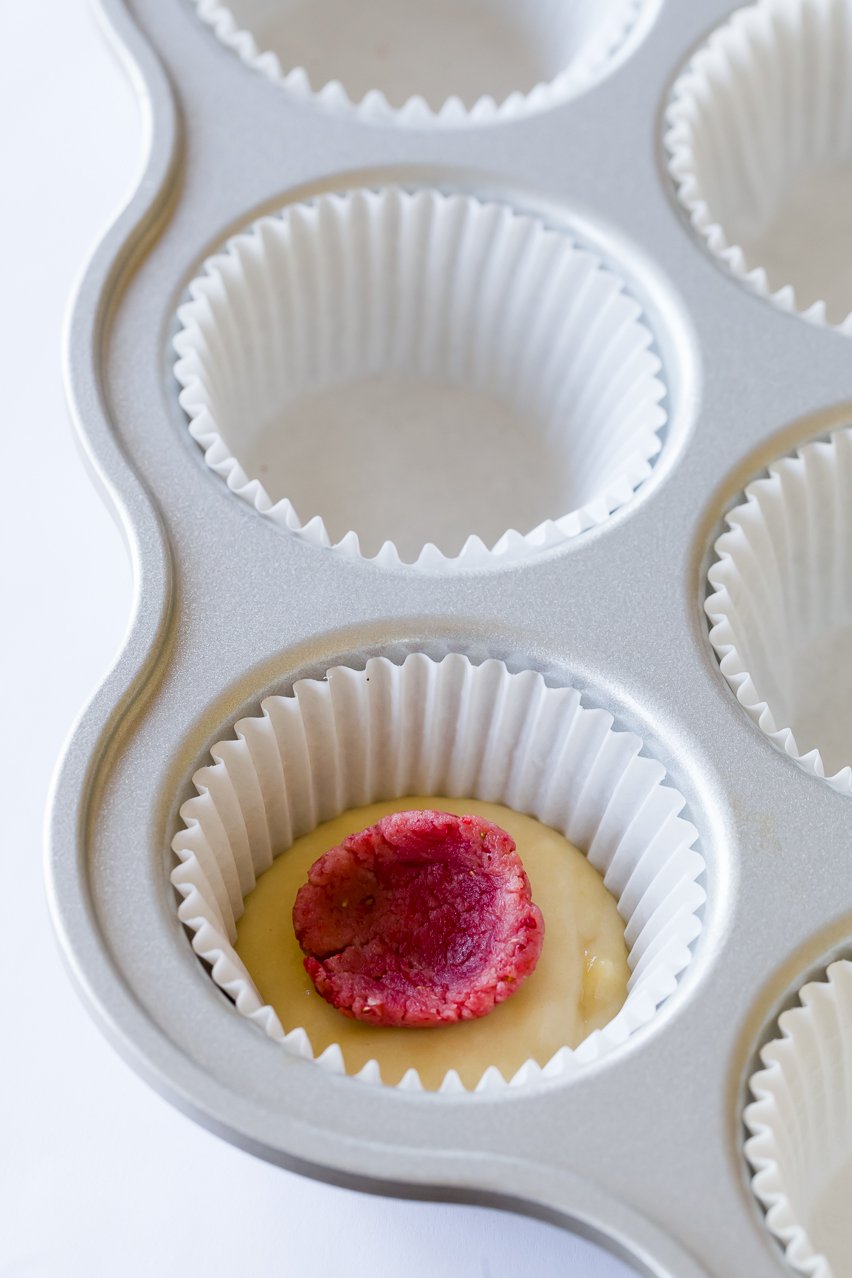 A red surprise-inside bunny placed into cupcake batter