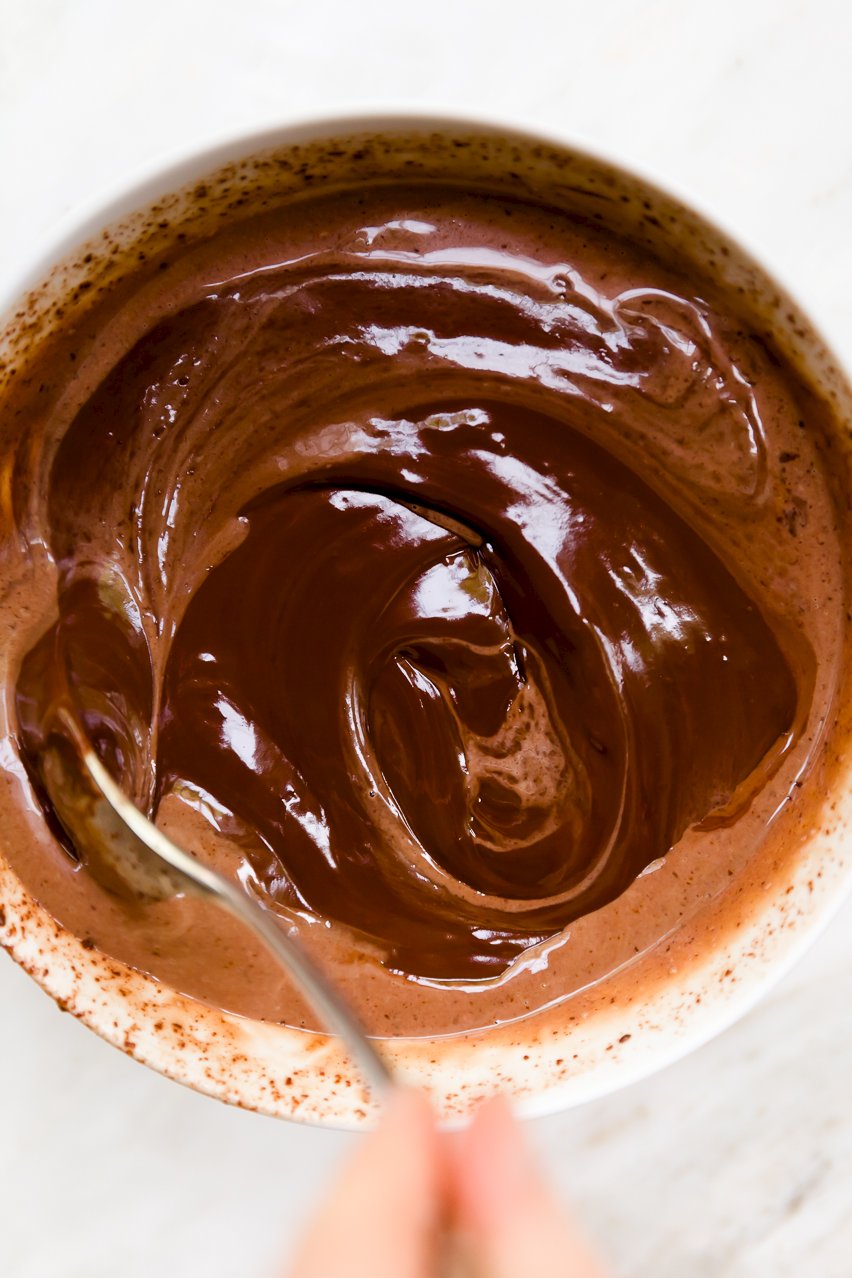 Overhead view of stirring chocolate with hot cream to make ganache