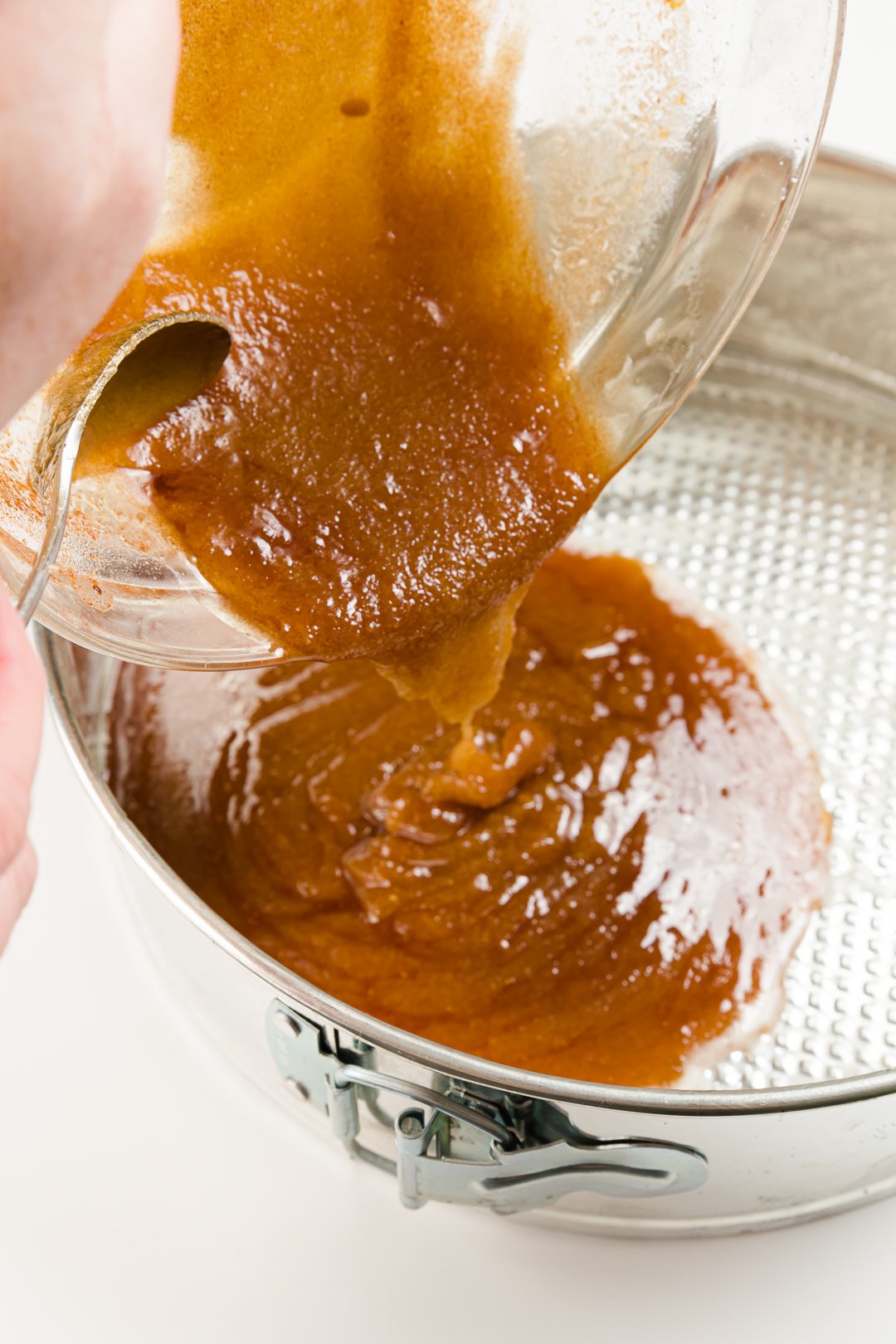 Pouring caramel into the bottom of a springform pan