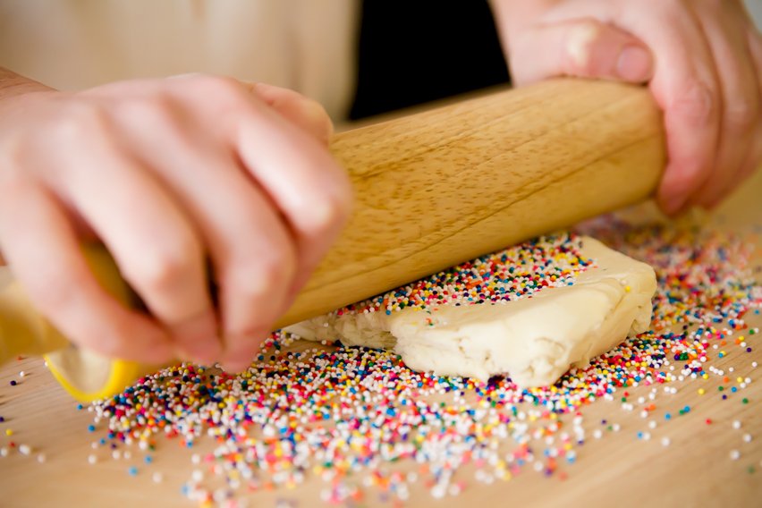 rolling Dutch cookies in sprinkles