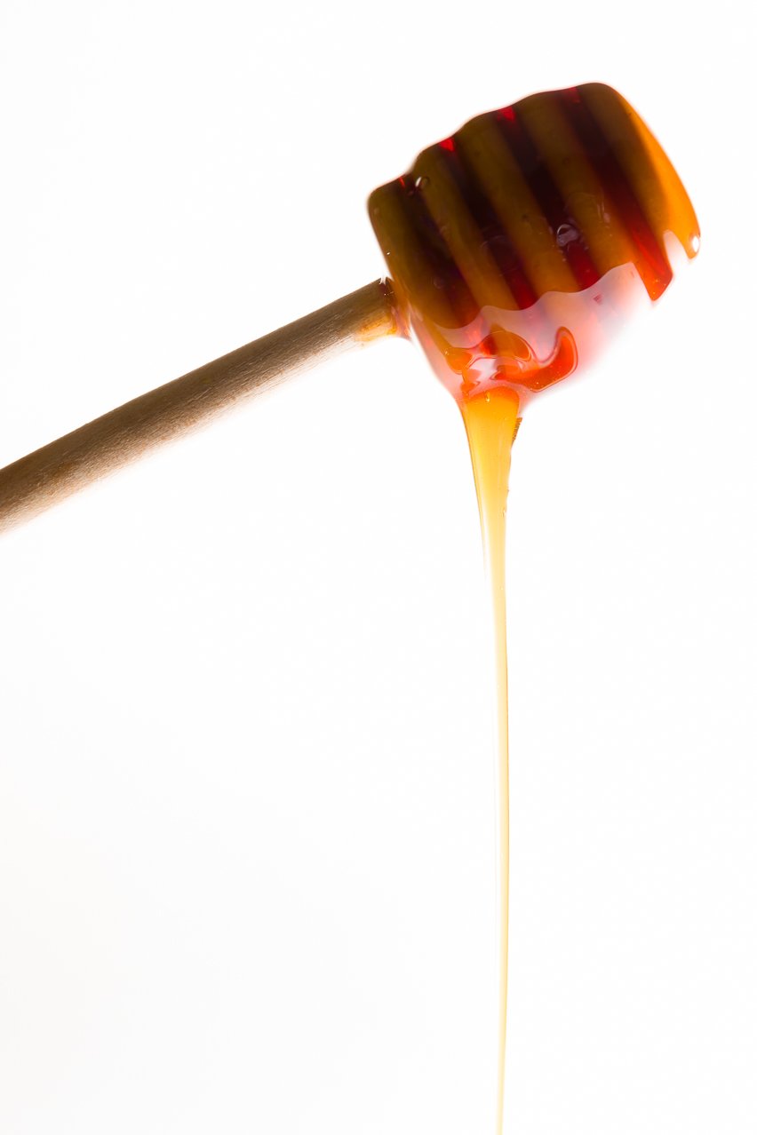 Honey dripping off of a honey dipper