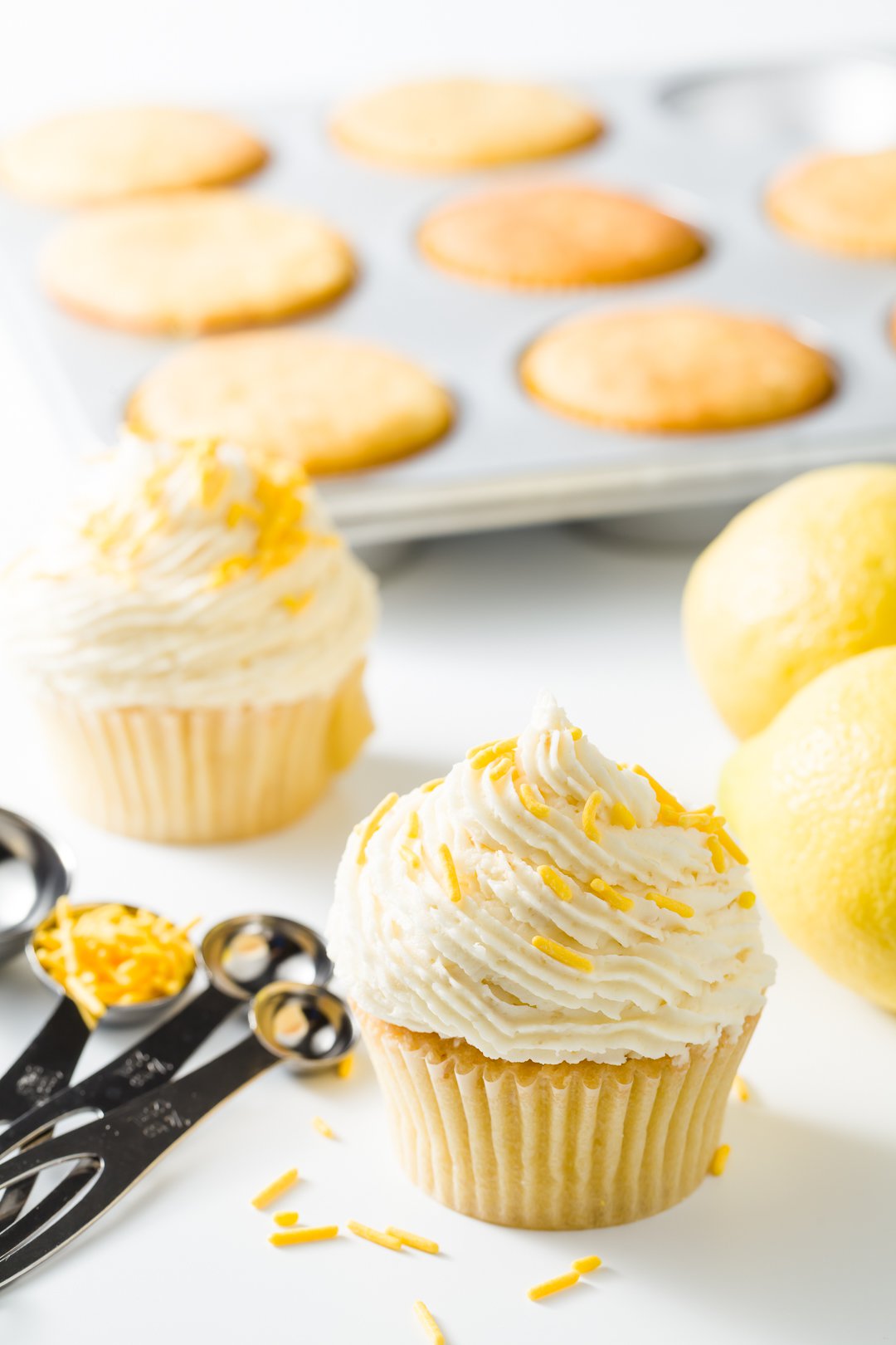 Lemon cupcakes in front of a cupcake tin