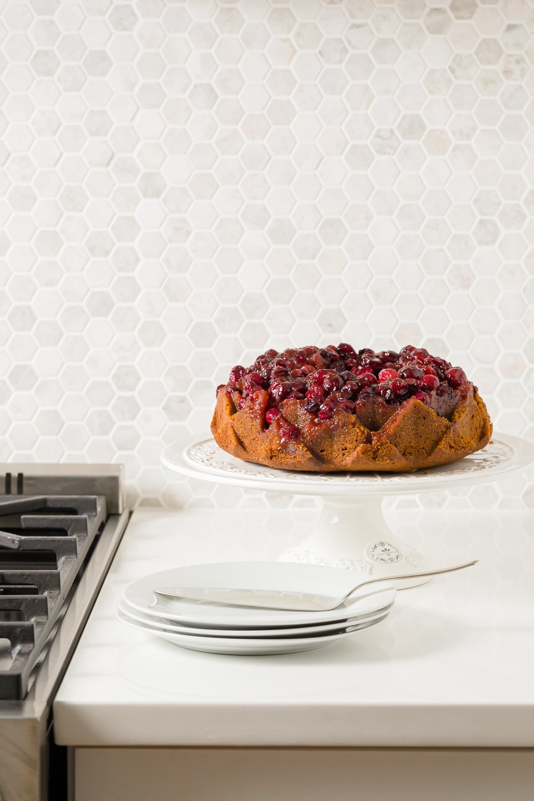 Cranberry cake on a cake stand on the counter